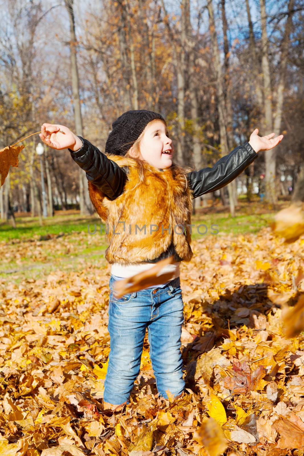 child the girl to stand in autumn park having stretched hands in the parties
