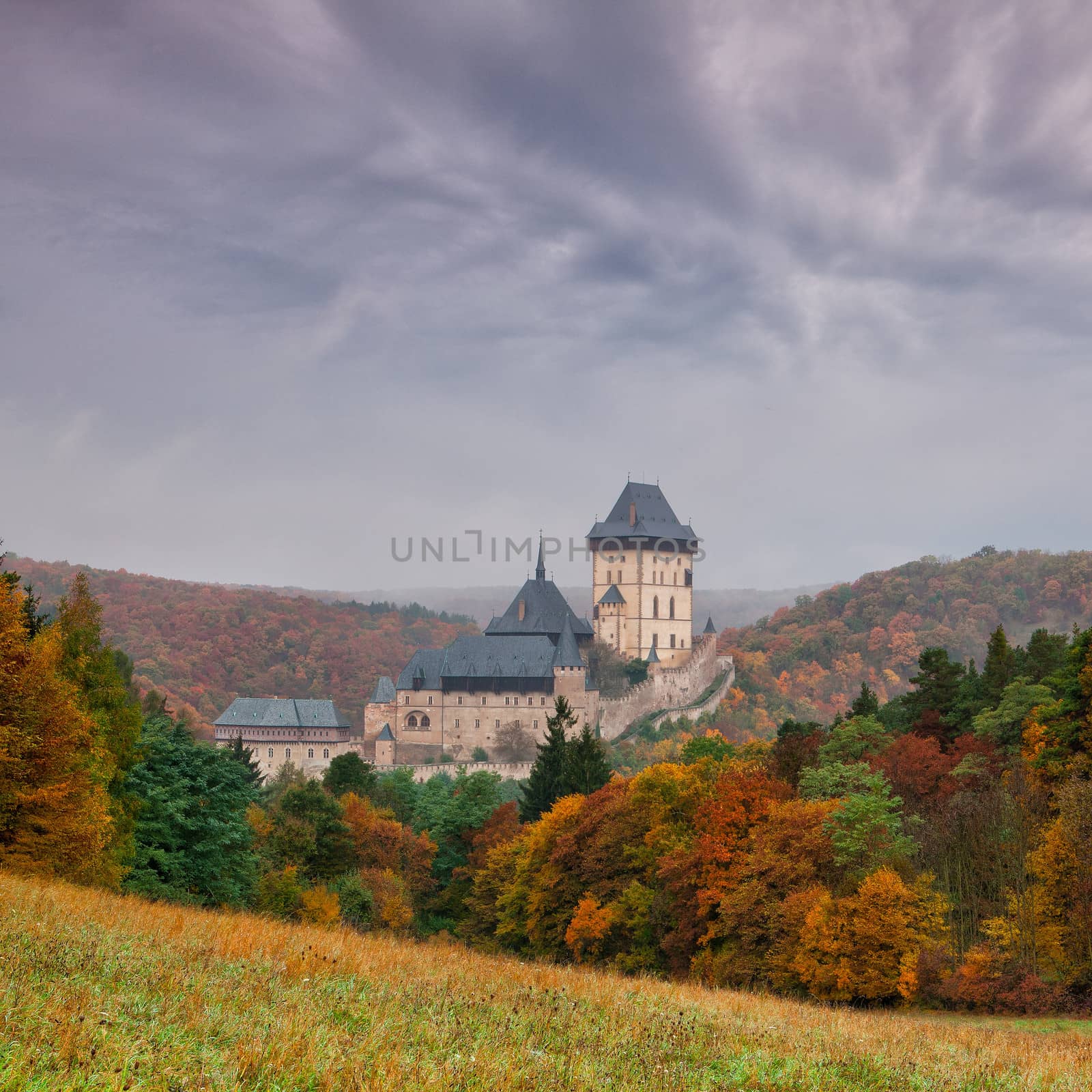 Karlstejn Castle in the autumn forest
