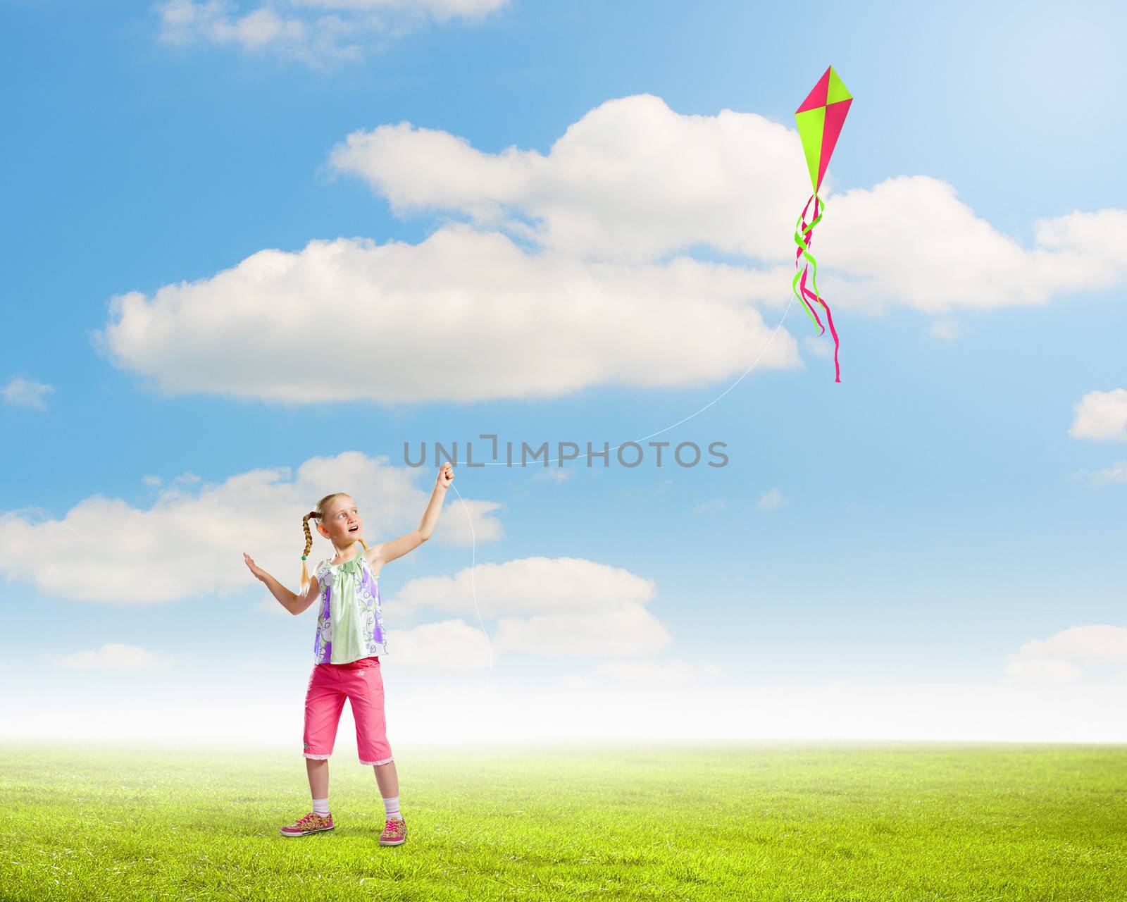 Image of little girl playing with kite at meadow