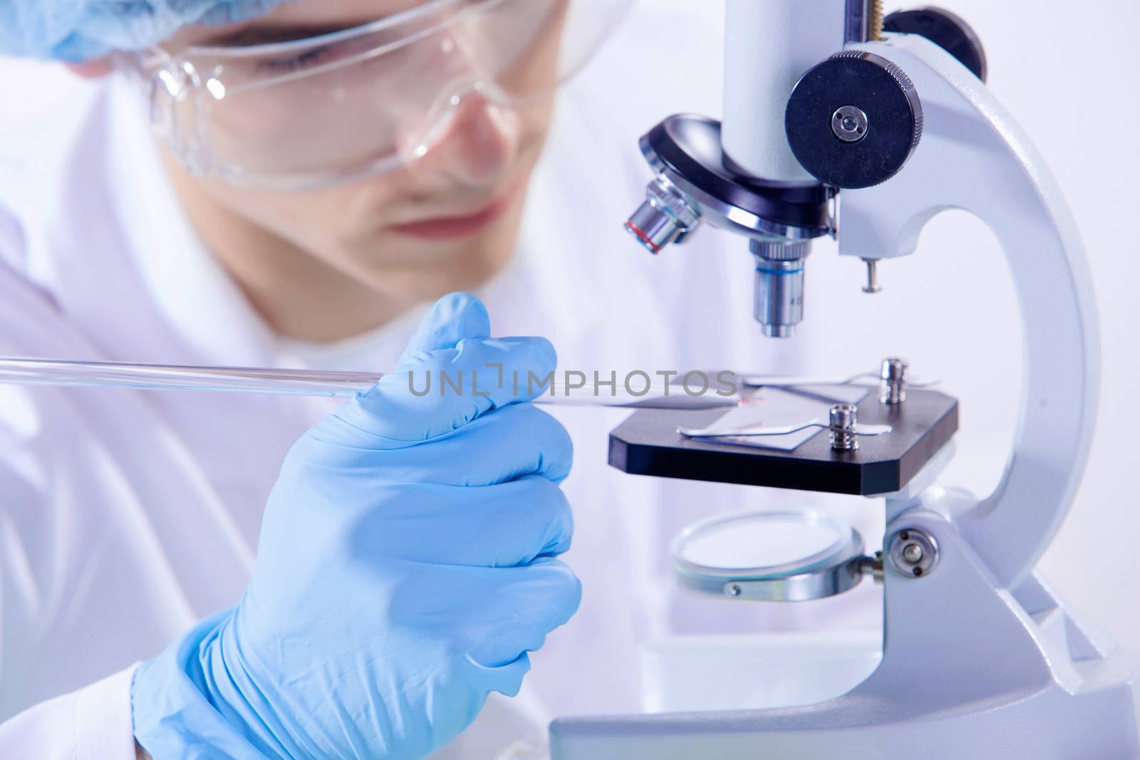 Image of man scientist working in laboratory with microscope