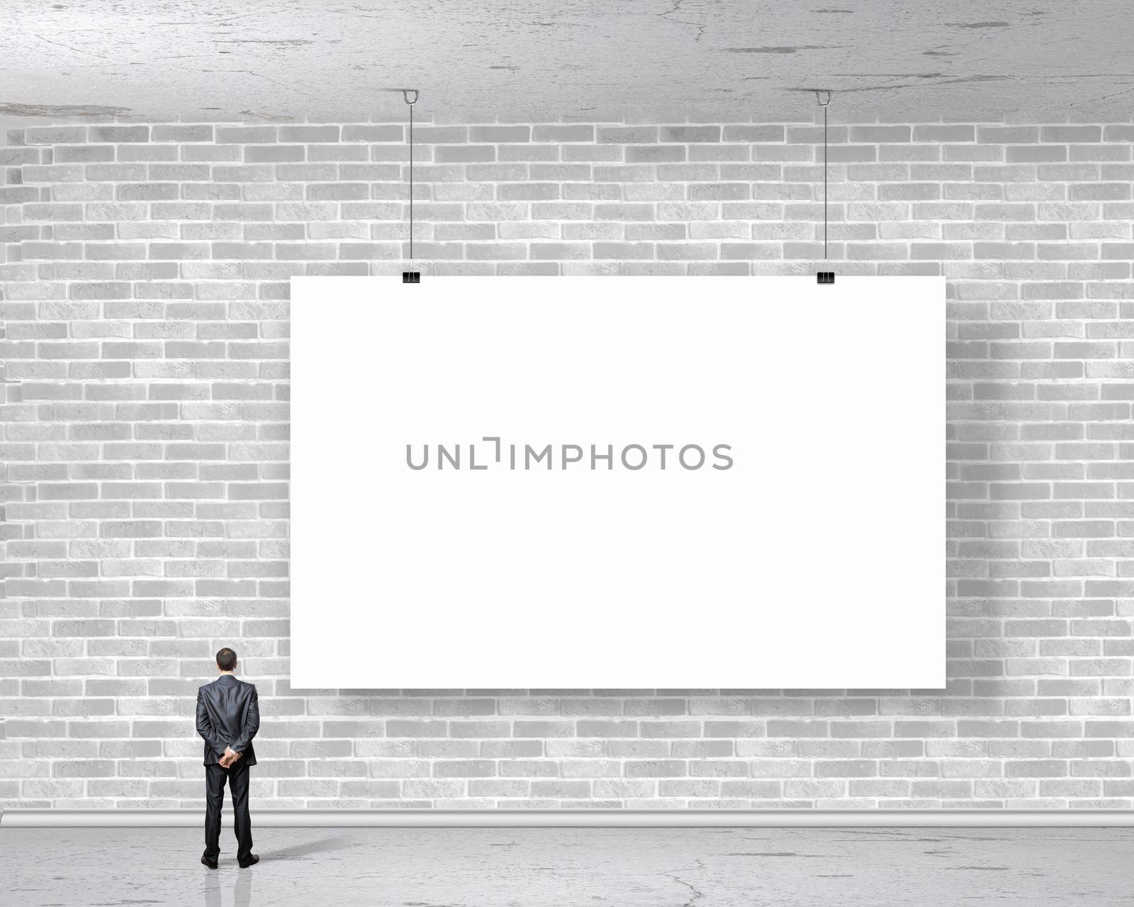 Image of businessman standing with back and looking at white banner