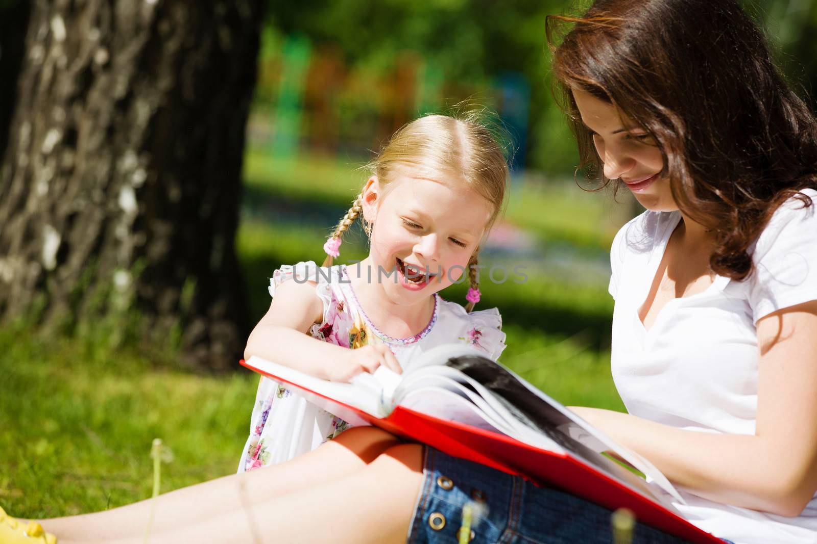 Image of cute girl and her mother playing in park