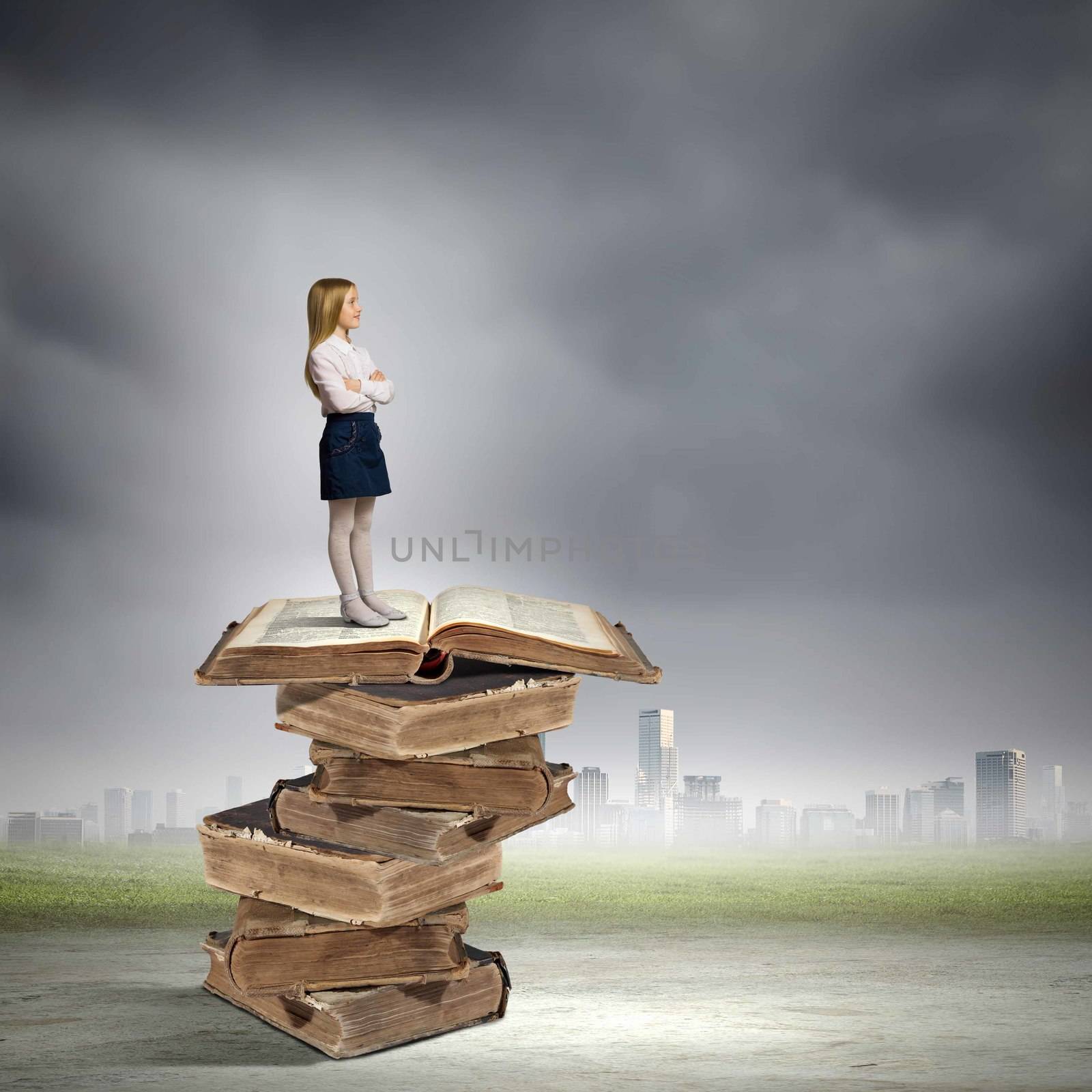Image of cute school girl standing on pile of books