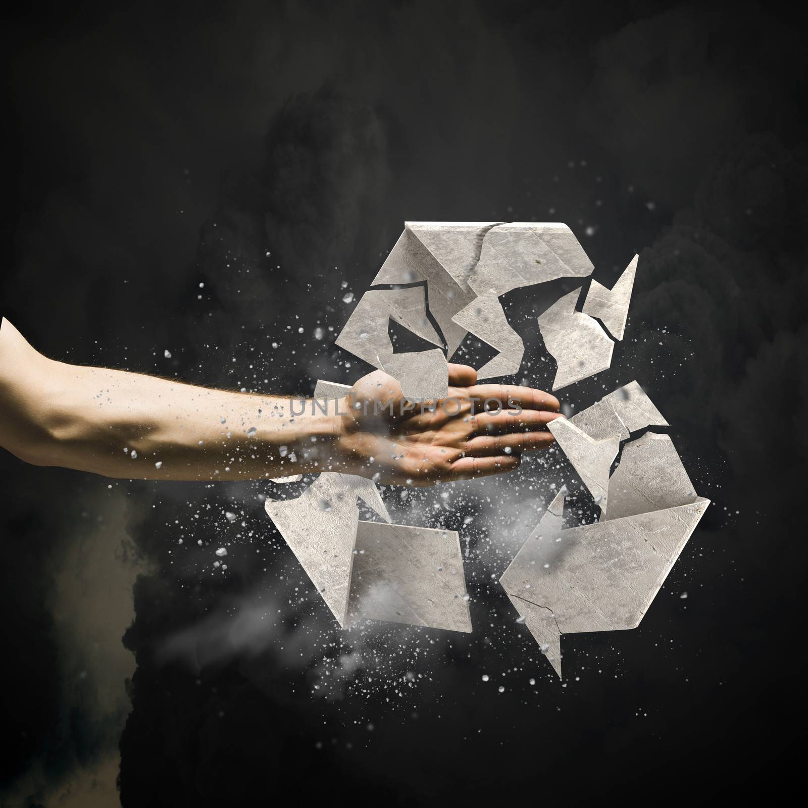 Close up image of human hand breaking recycle stone symbol