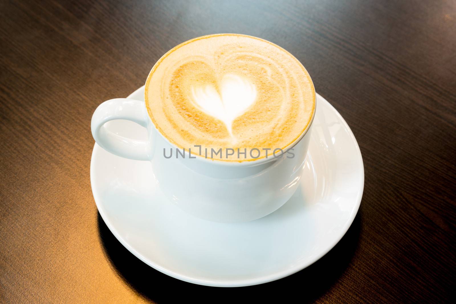 Cup of latte coffee with heart symbol