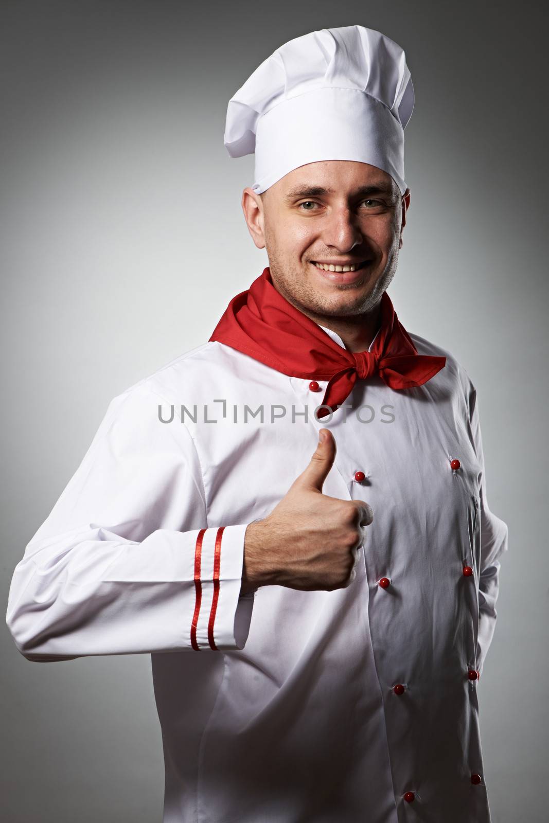 Male chef with thumb up portrait against grey background