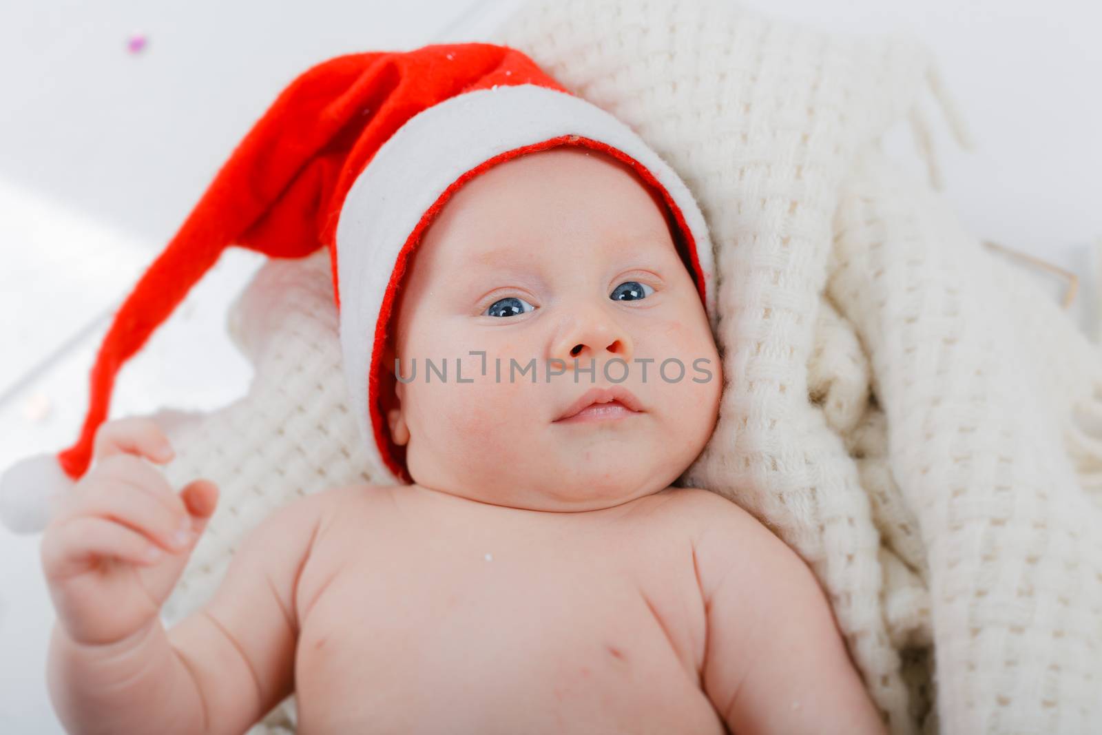 Christmas theme. Portrait of baby boy in a Santa hat in studio