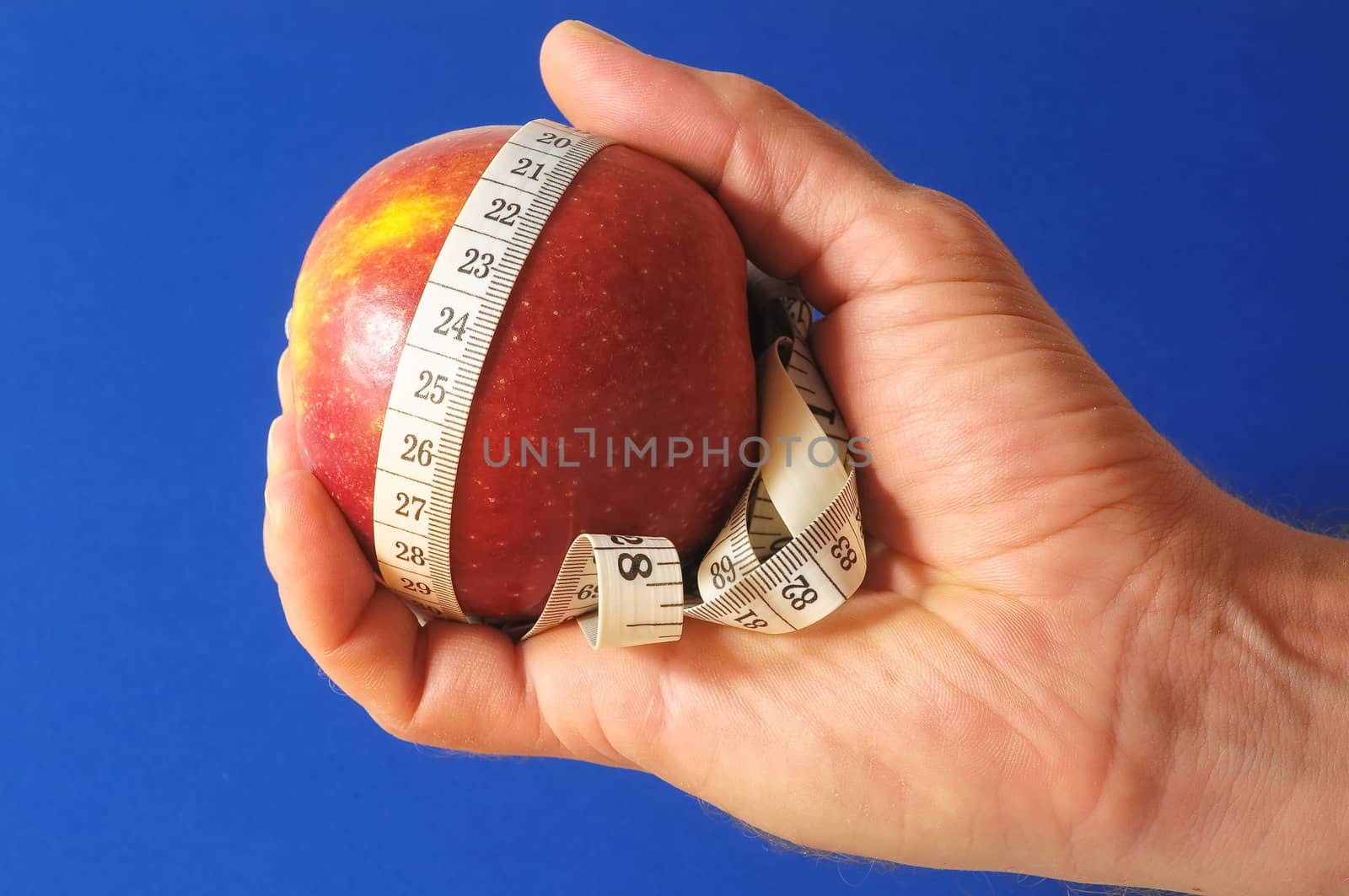 Diet Apple and Meter on the Hand on a Colored Background 