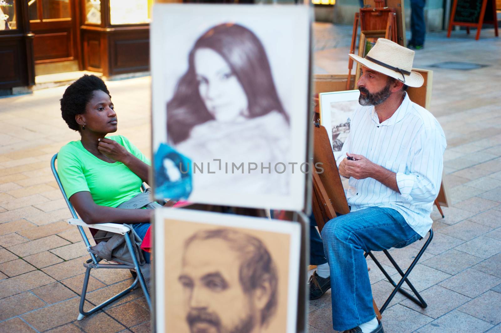 Bratislava, Slovakia - August 31, 2013: Unknown painters drawing the portraits of tourists at Old Town stret of Bratislava . Bratislava's Old Town is known for its many churches, a riverbank promenade and cultural institutions.