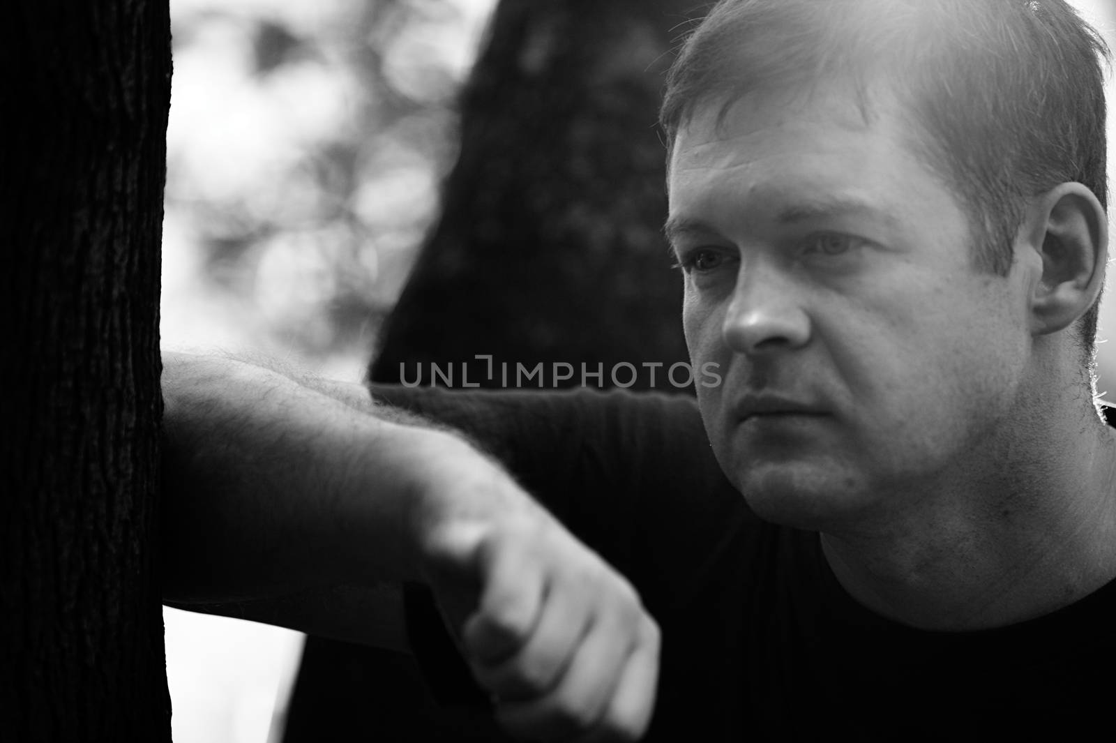 Black and white close up portrait of a forty-year-old man in deep thoughts. Midlife crisis.