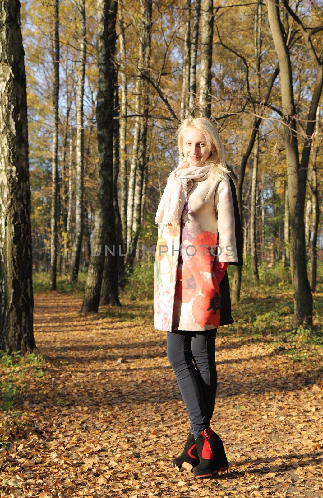 Pretty smiling girl posing in autumn park