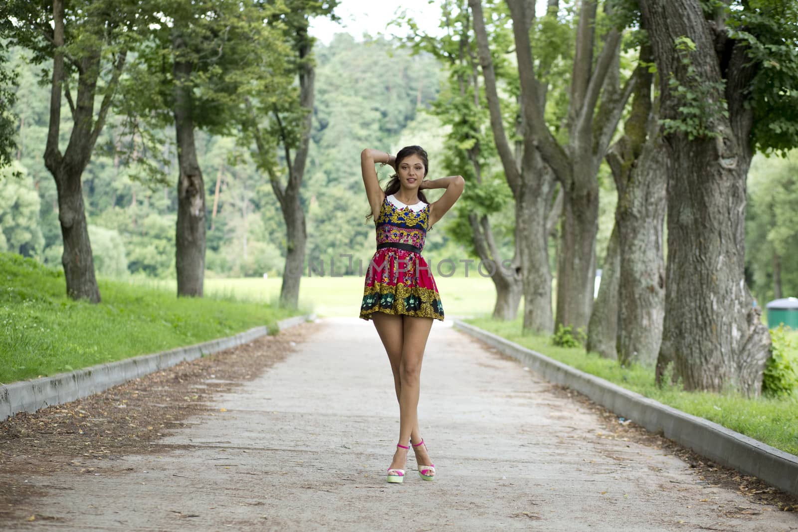 Full growth, beautiful young woman in color dress