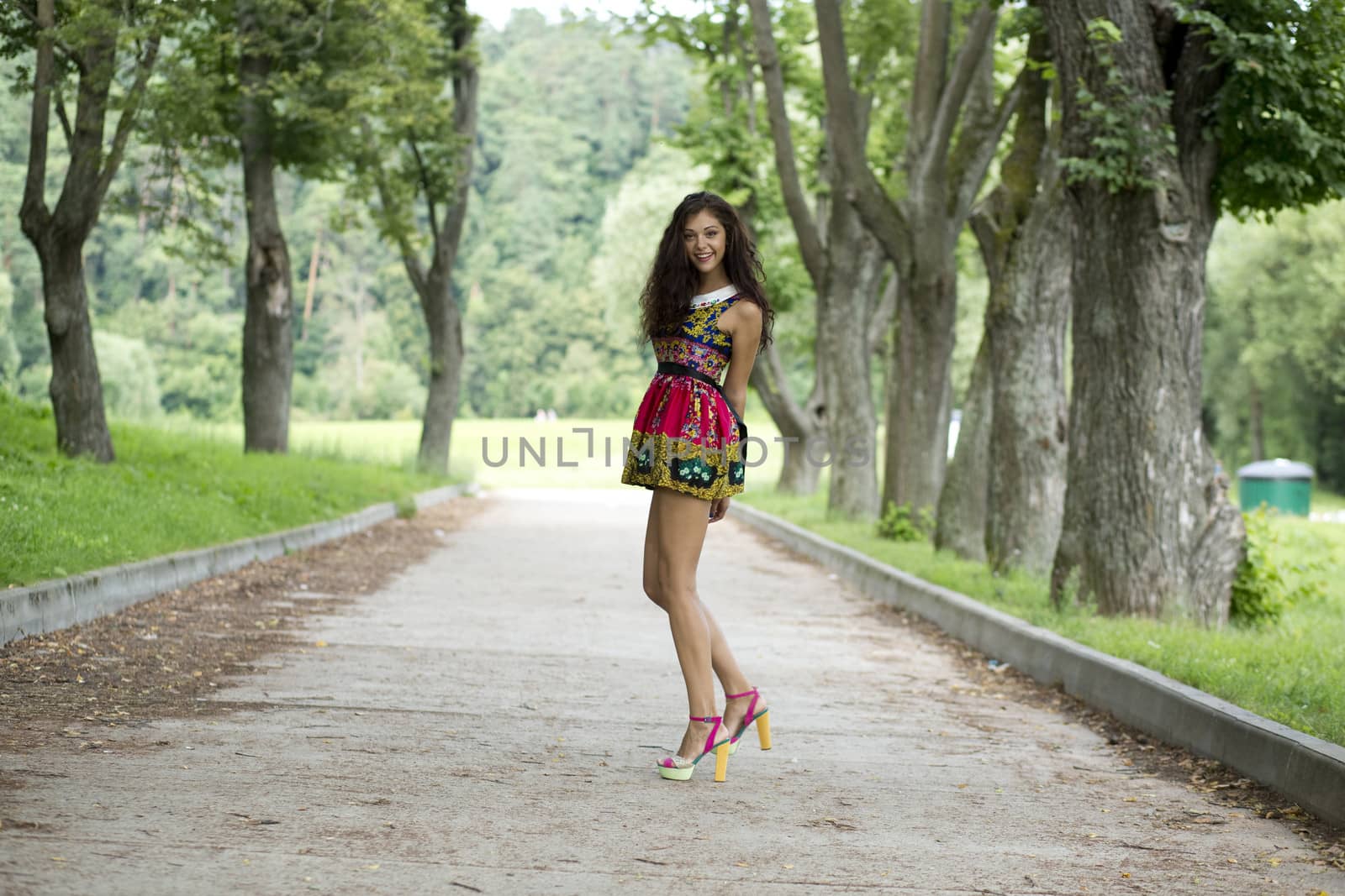 Full growth, beautiful young woman in color dress
