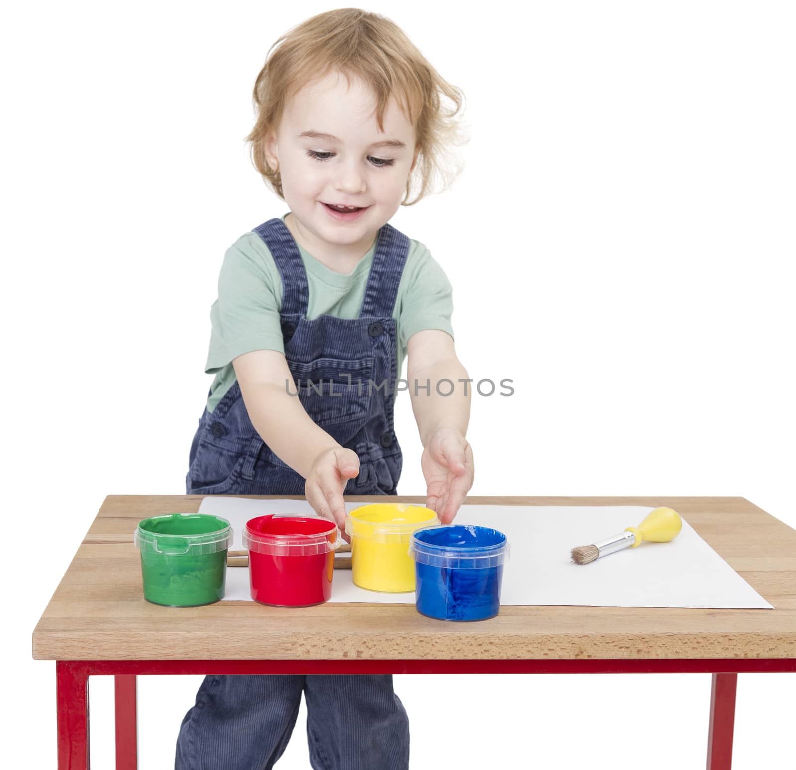 child with finger paint on wooden desk isolated in white background