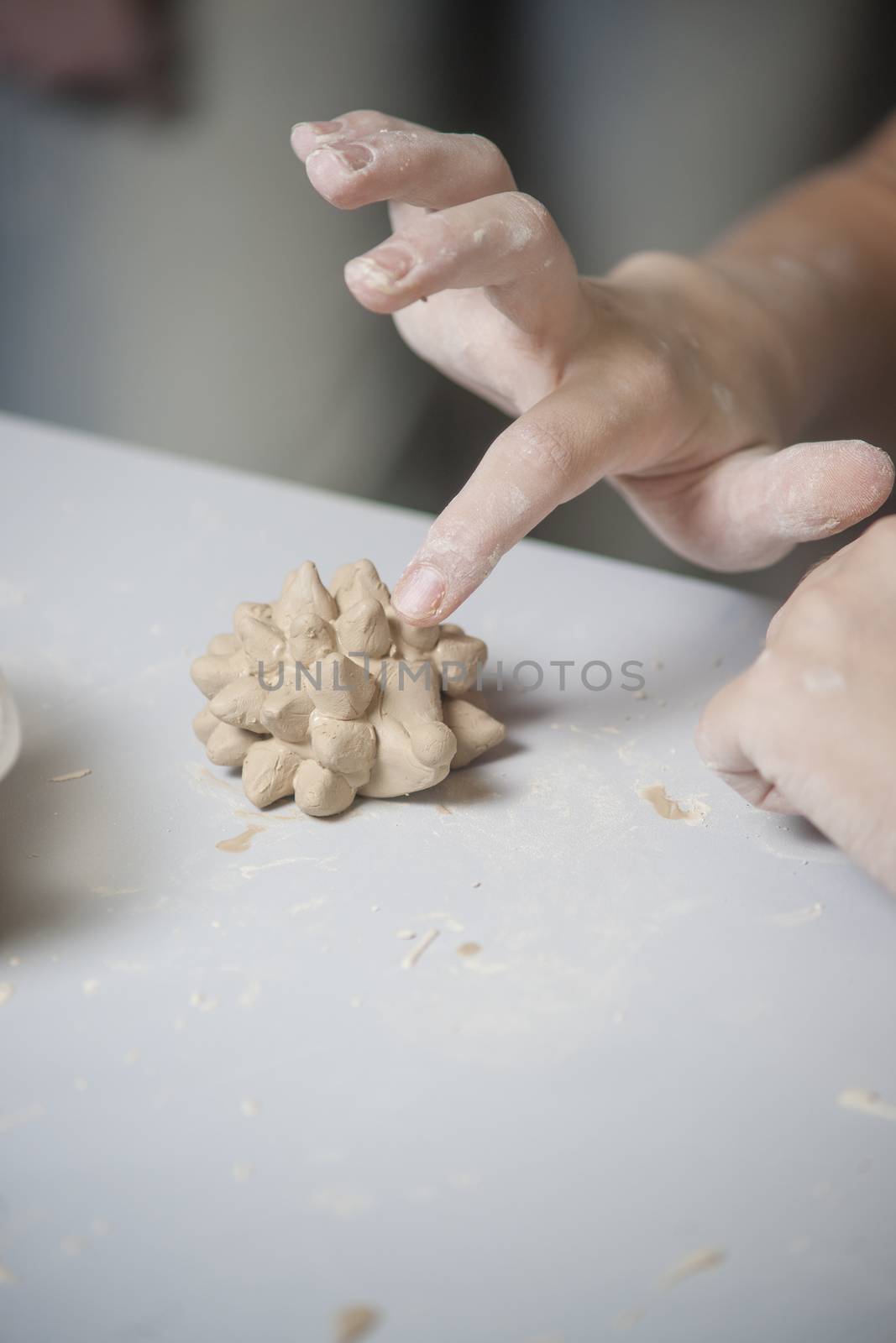 Girl make toy from clay. High resolution image.