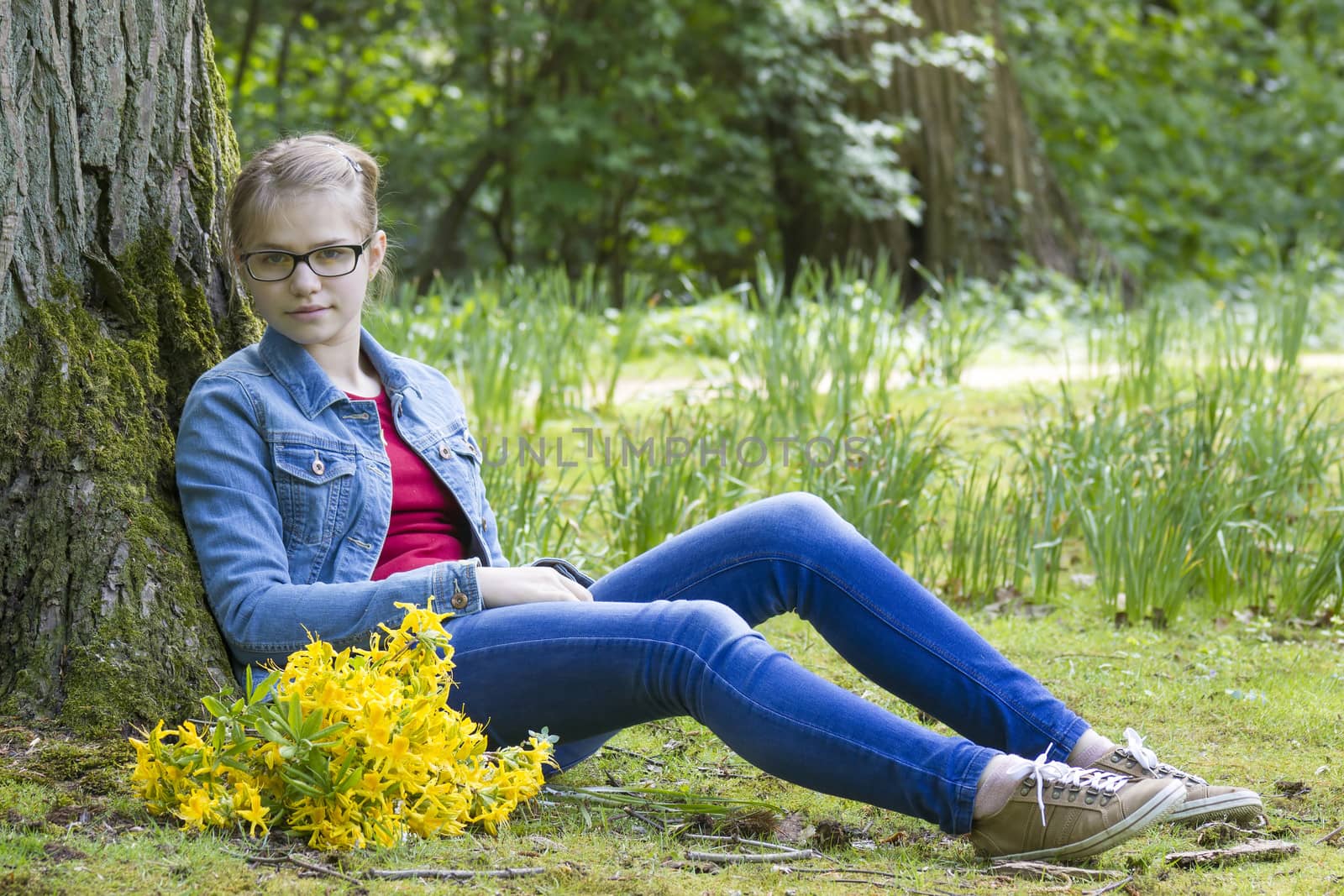 girl with big bouquet of spring flowers sitting in the park