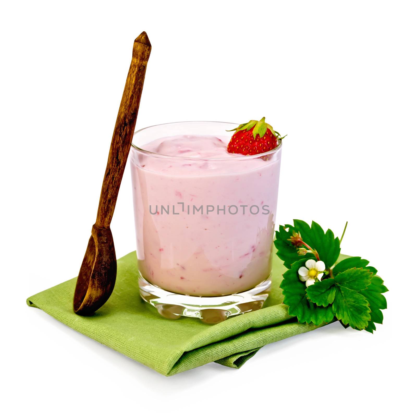 Milkshake with strawberries in a glass, wooden spoon, strawberry flower with leaves on a napkin isolated on white background
