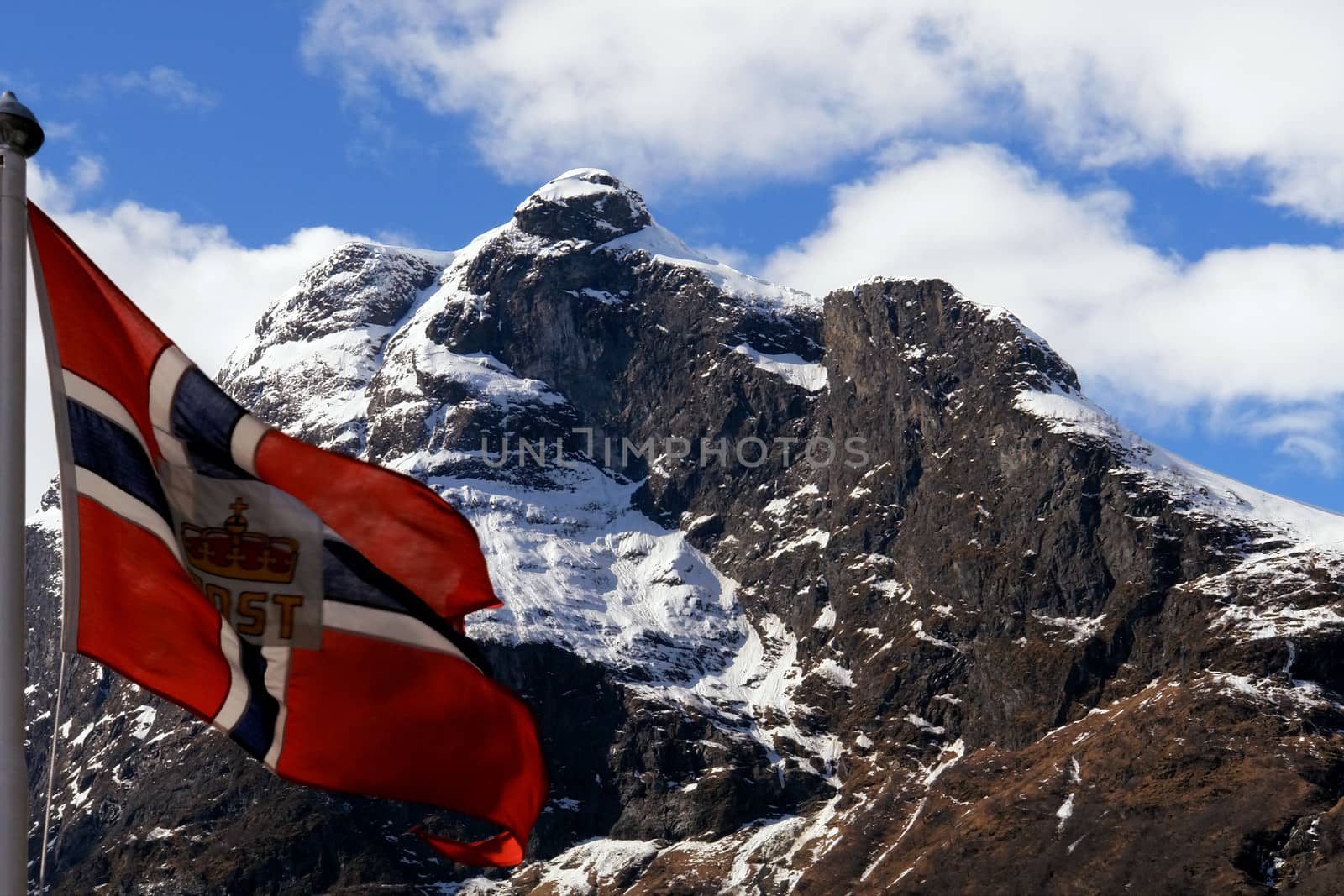 Norway flag in the wind, in mountain landscape, Gudvangen Fjord