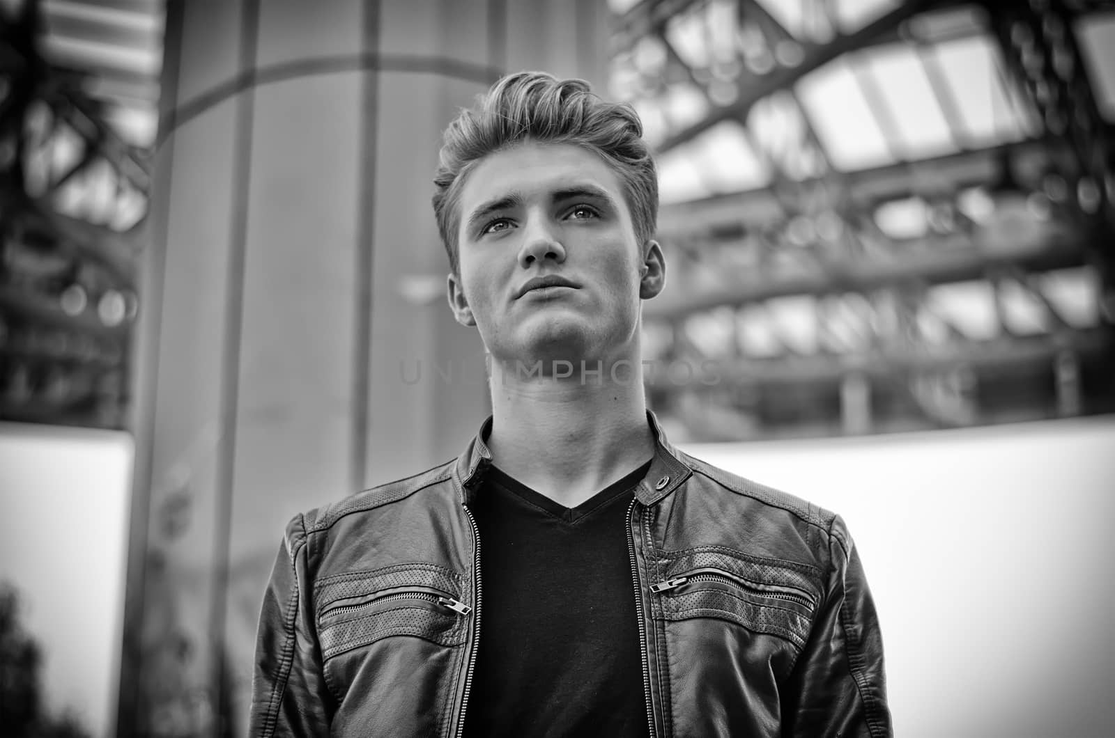 Attractive blond young man in city environment, black and white shot