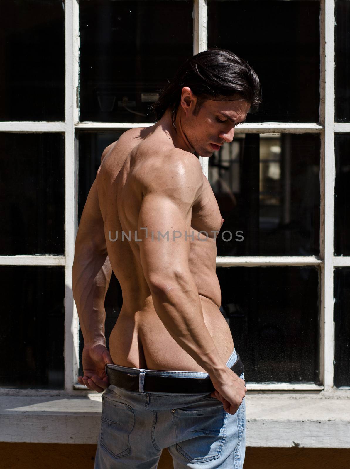 Attractive muscleman shirtless outdoors, partly showing ass