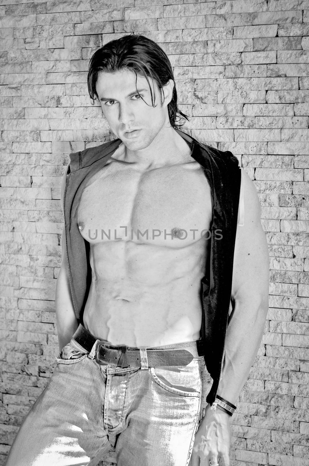 Muscular young bodybuilder showing ripped abs and pecs, black and white shot