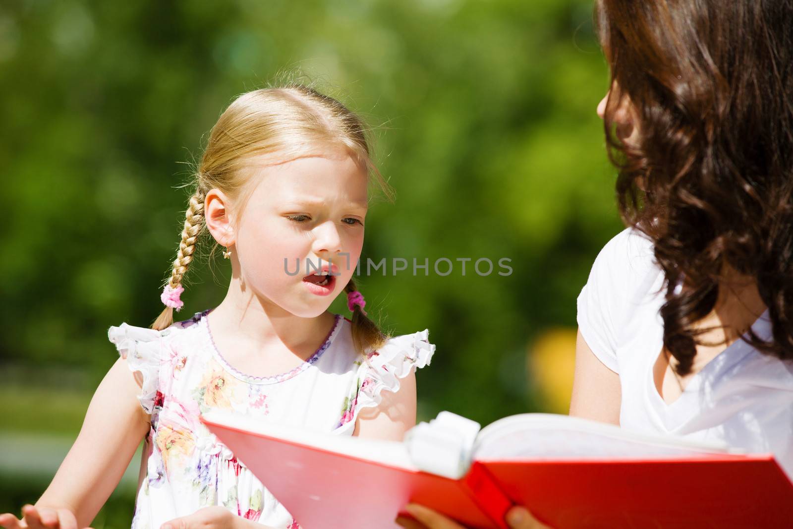 Image of cute girl and her mother playing in park