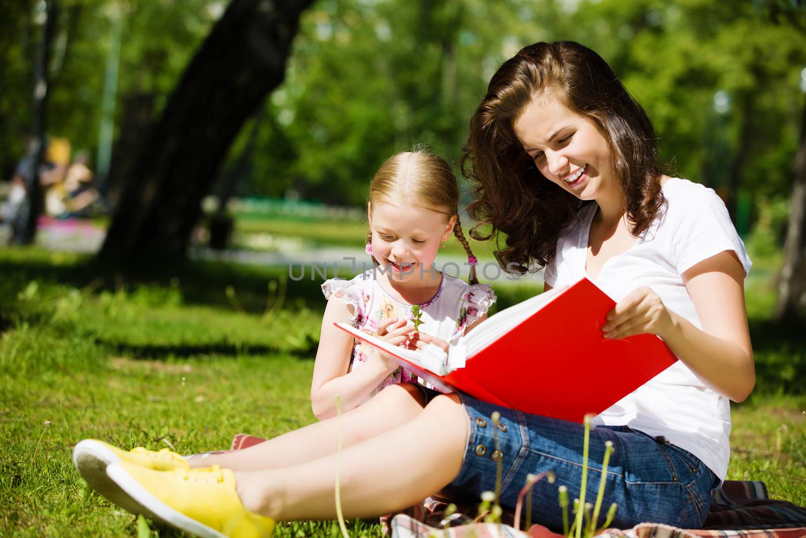 Image of cute girl and her mother playing in park