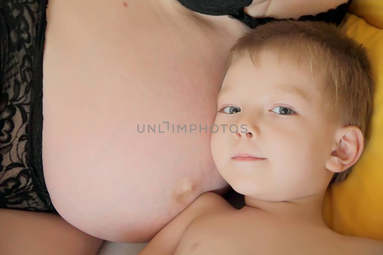 Portrait of cute boy with pregnant mother belly