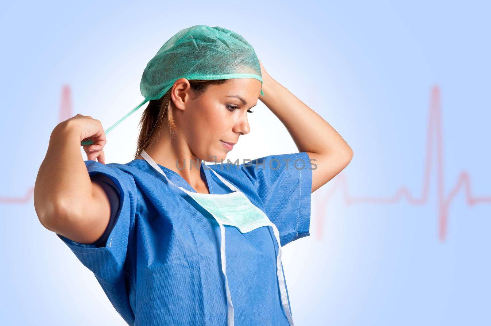 Young female surgeon getting ready for a surgery, with an EKG graph behind her