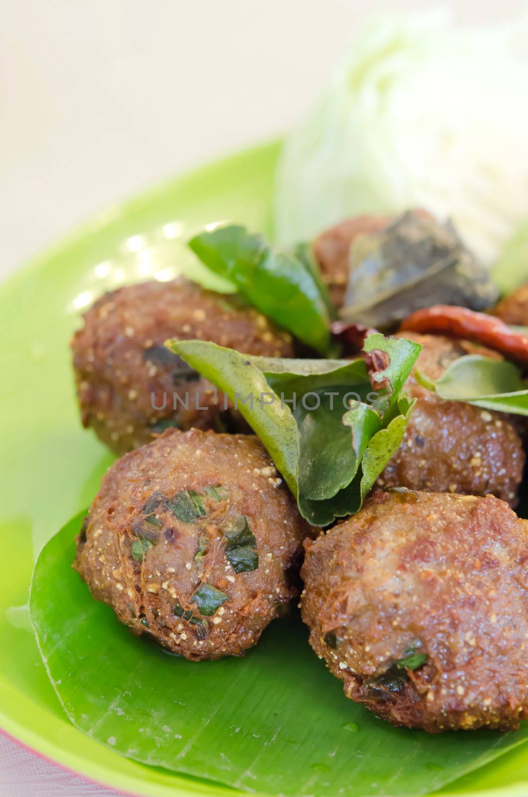 Meatballs with greens on salad leaves closeup