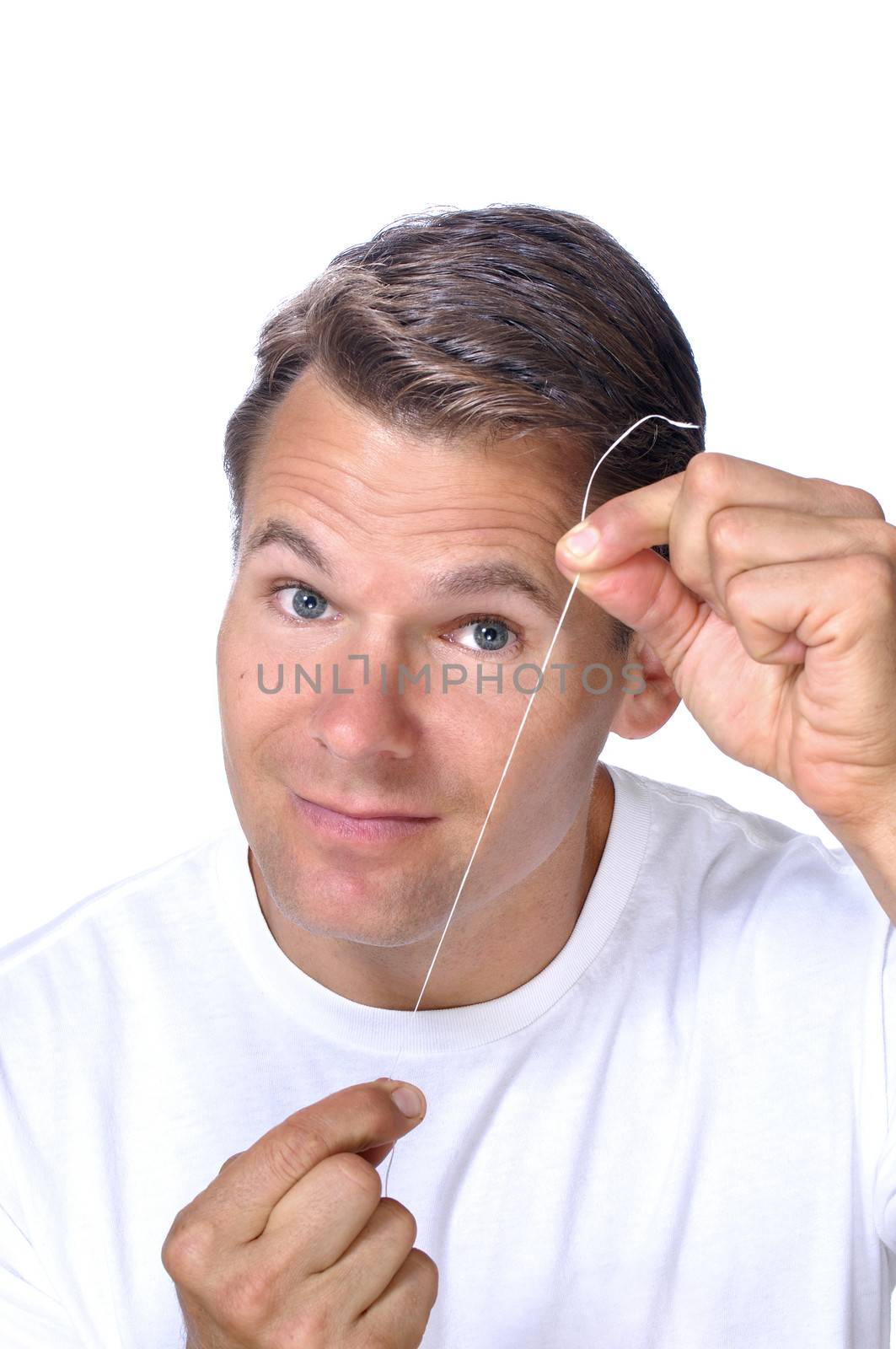 Handsome Caucasian man shows white floss to camera to remind you to floss