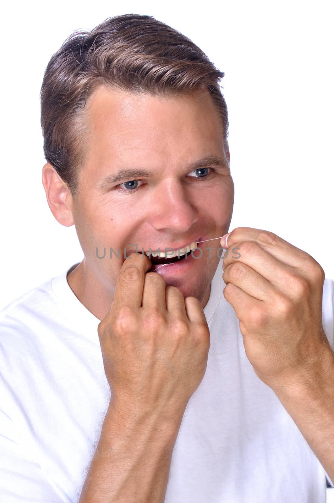 Handsome Caucasian man cleans his teeth with dental floss on white background