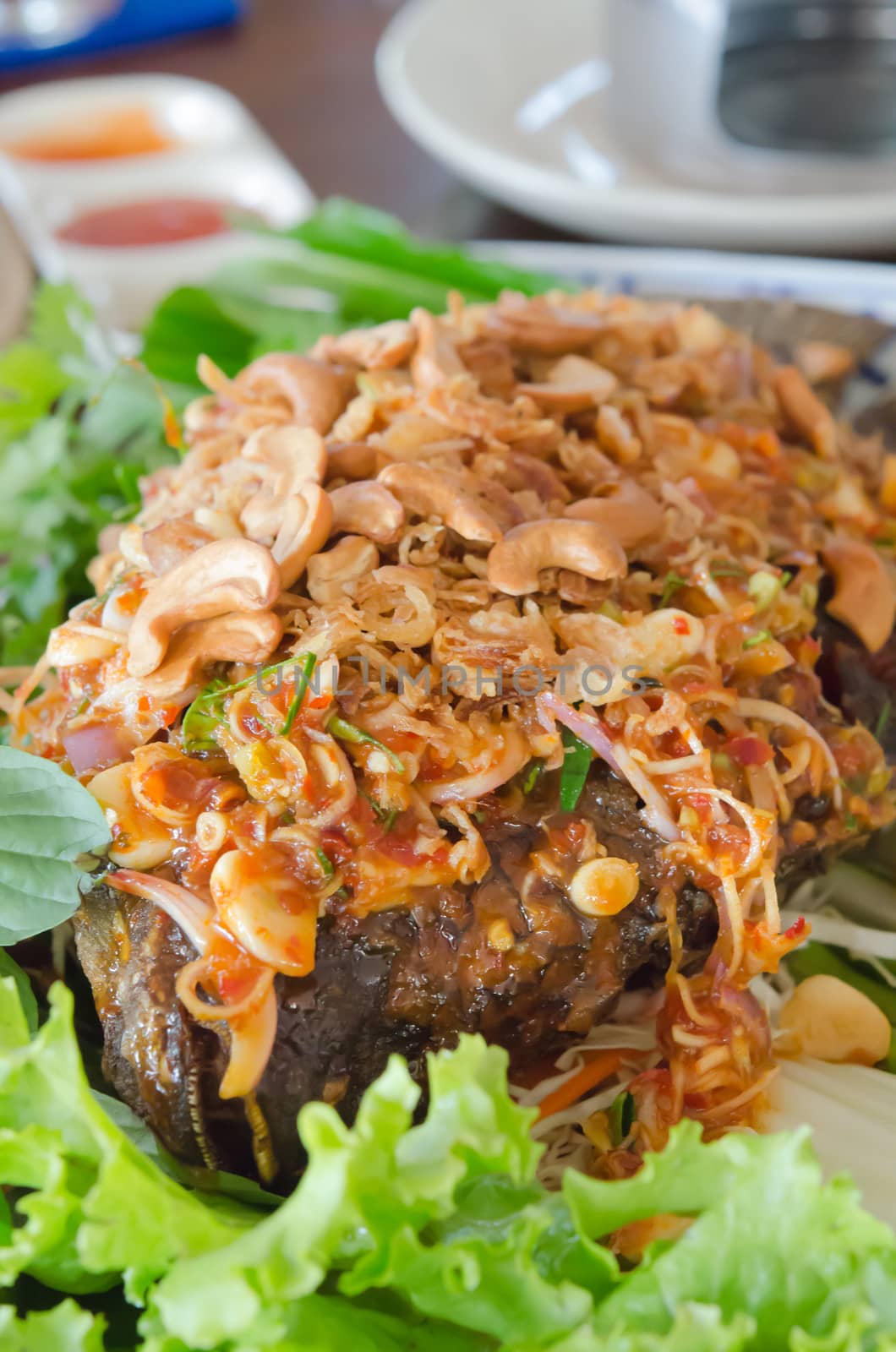 fried fish served with fresh vegetable and spicy sauce on top 