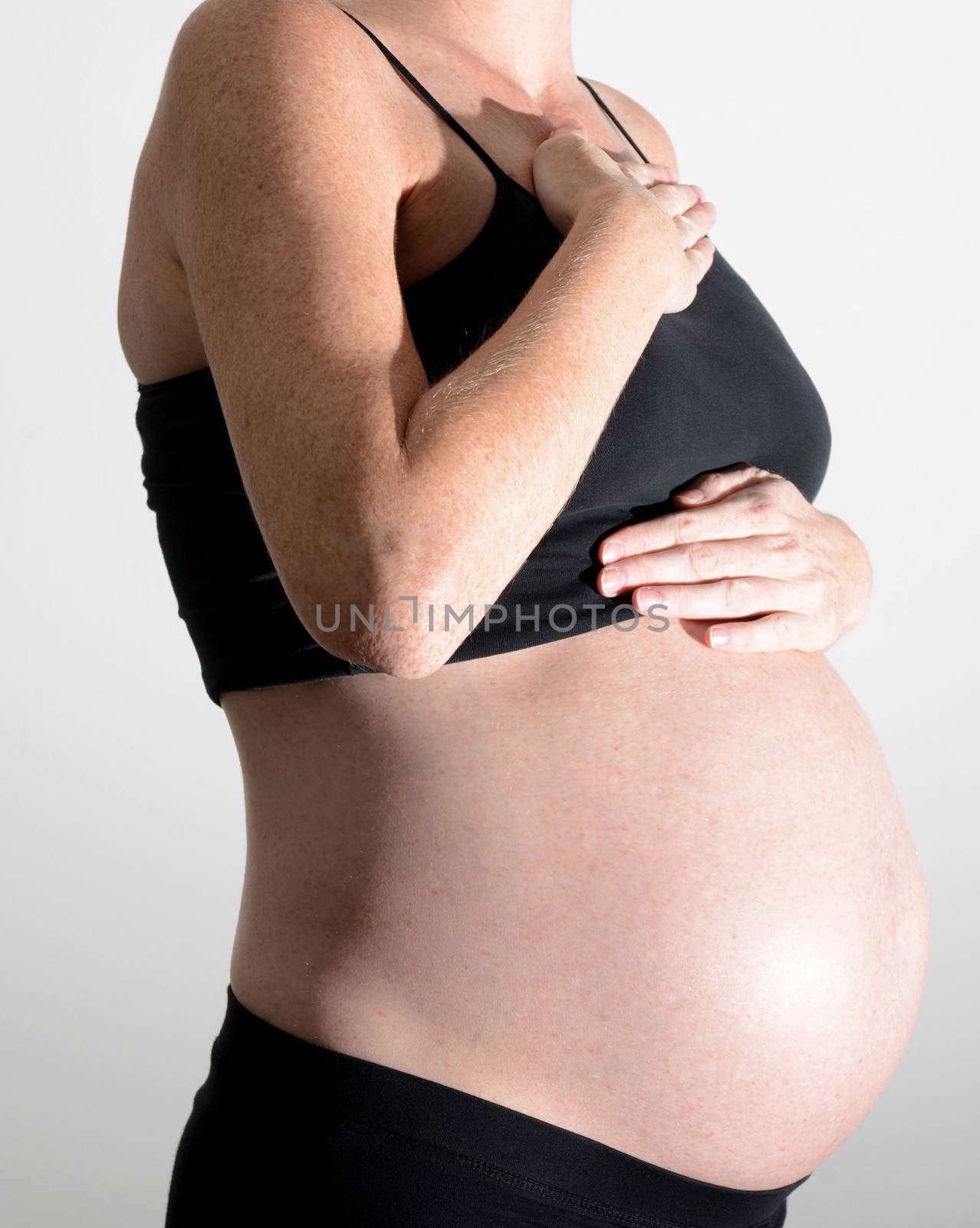 pregnant woman holding chest and throat from heartburn 
