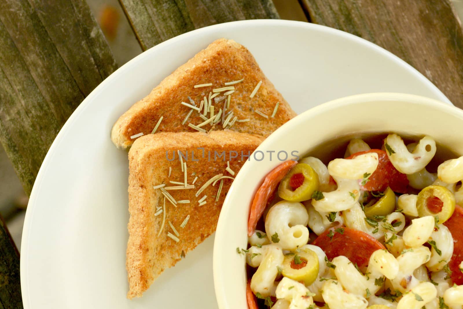 garlic bread and pasta salad on wood