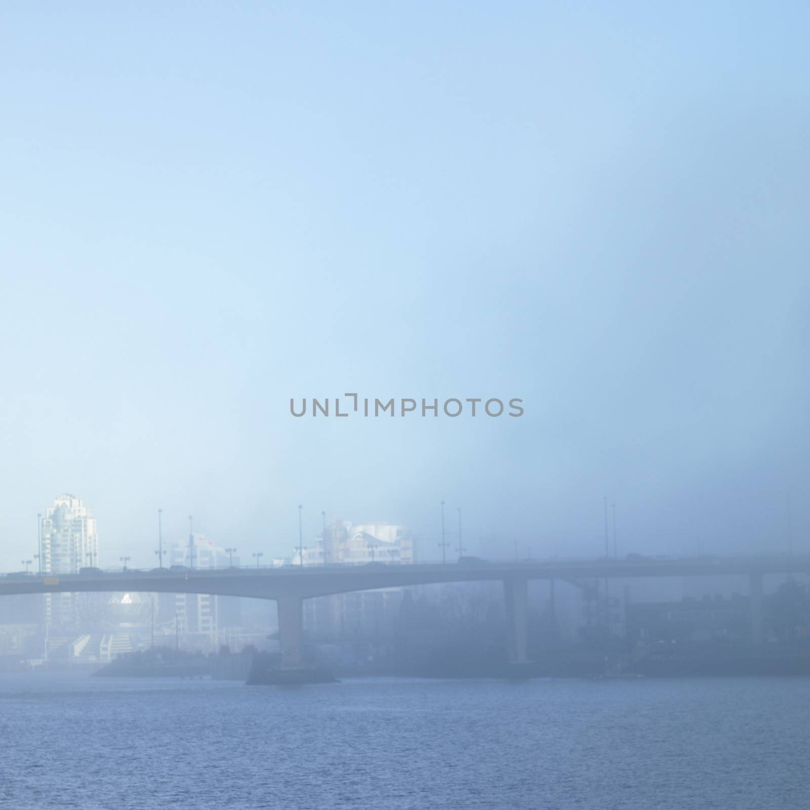 Bridge and cityscape on a foggy day.