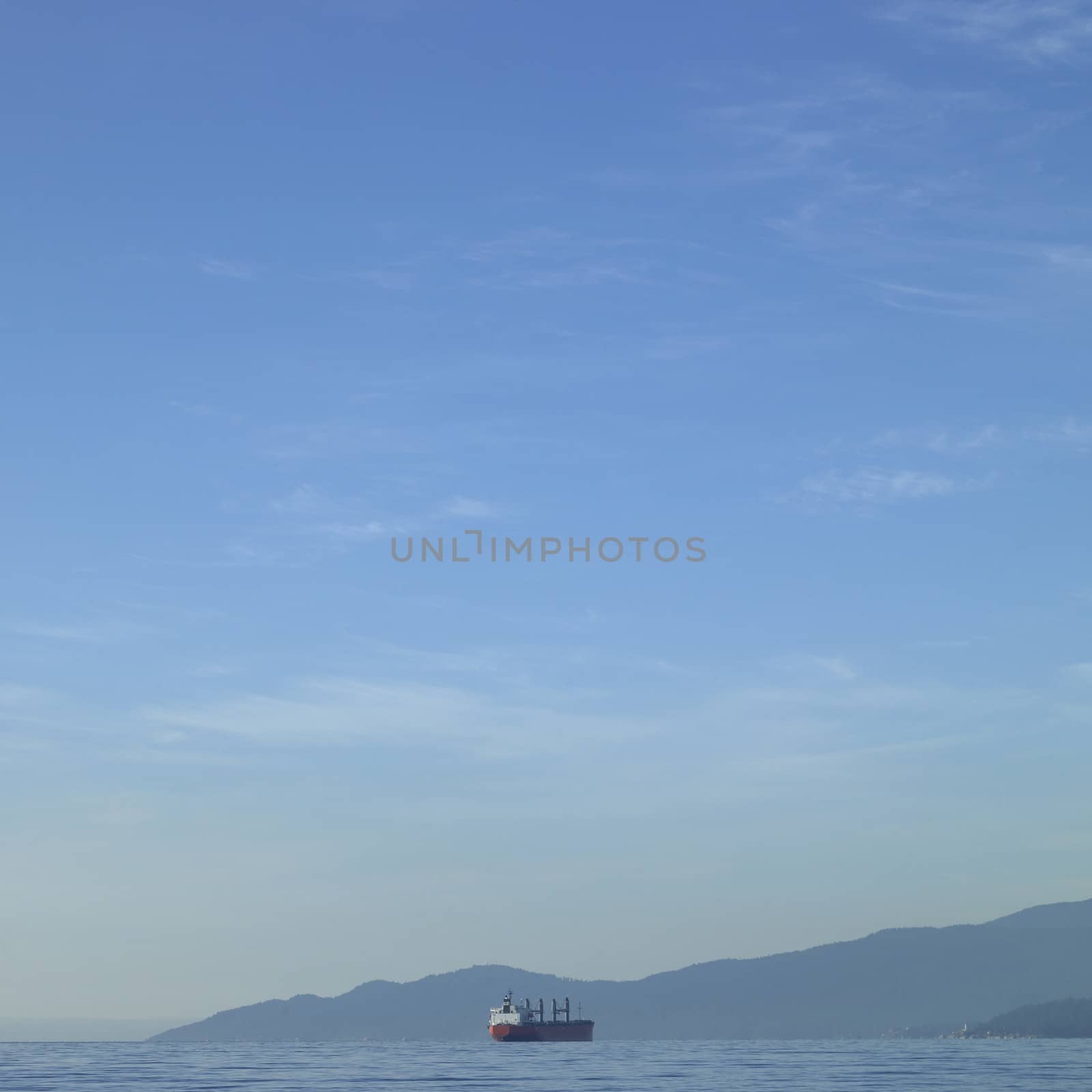 Large vessel on the ocean with mountains in the background