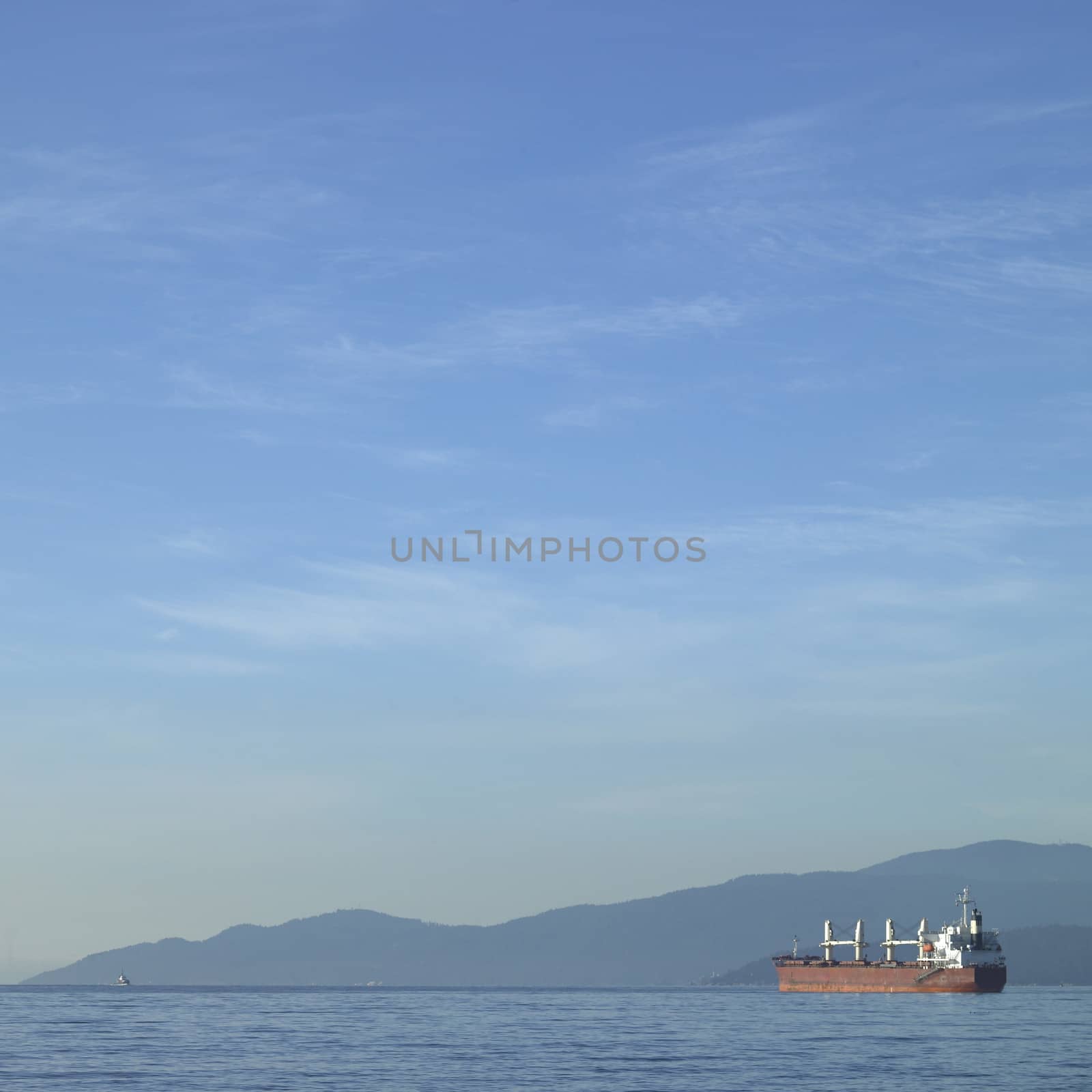 Large vessel on the ocean with mountains in the background