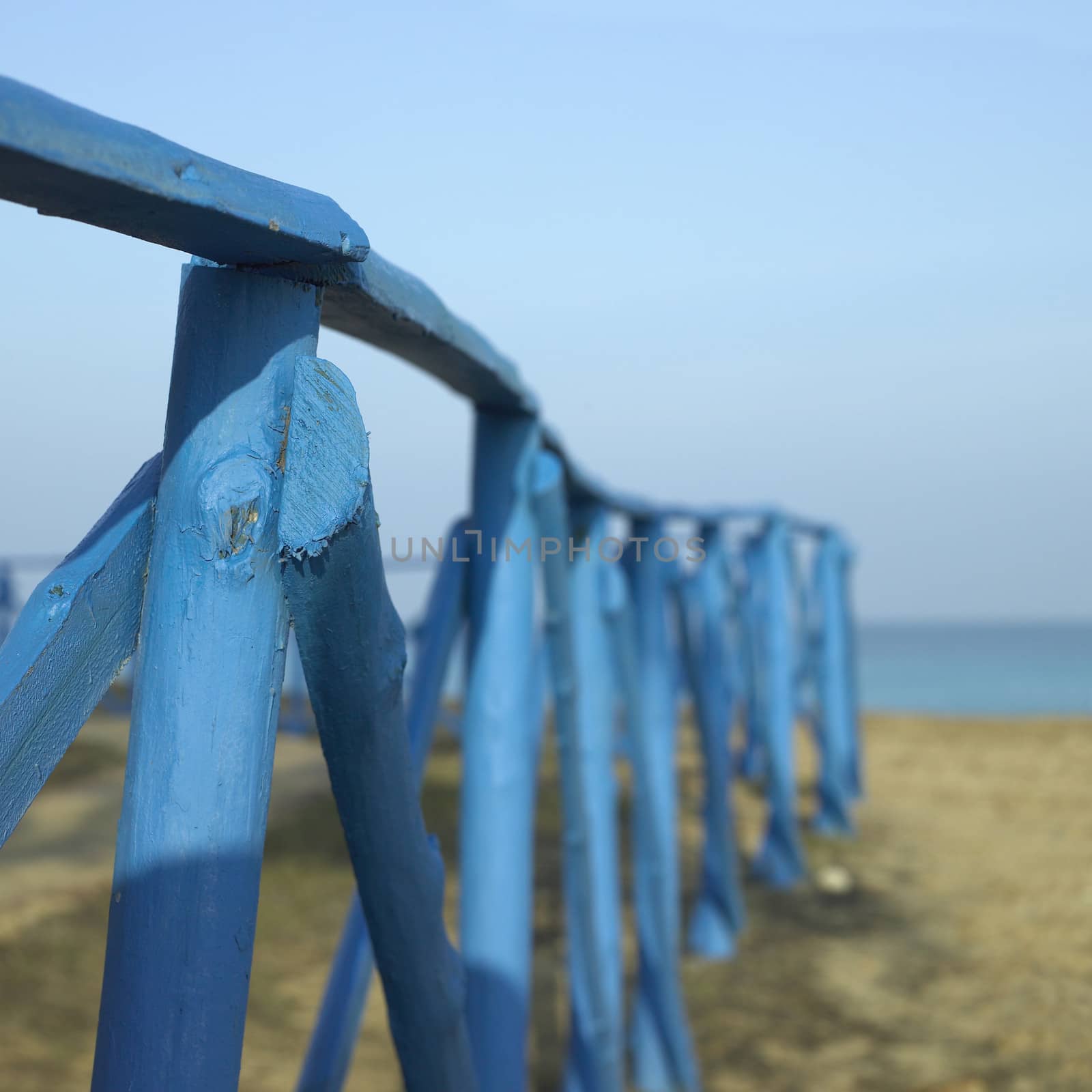 Blue wooden fence near the sea