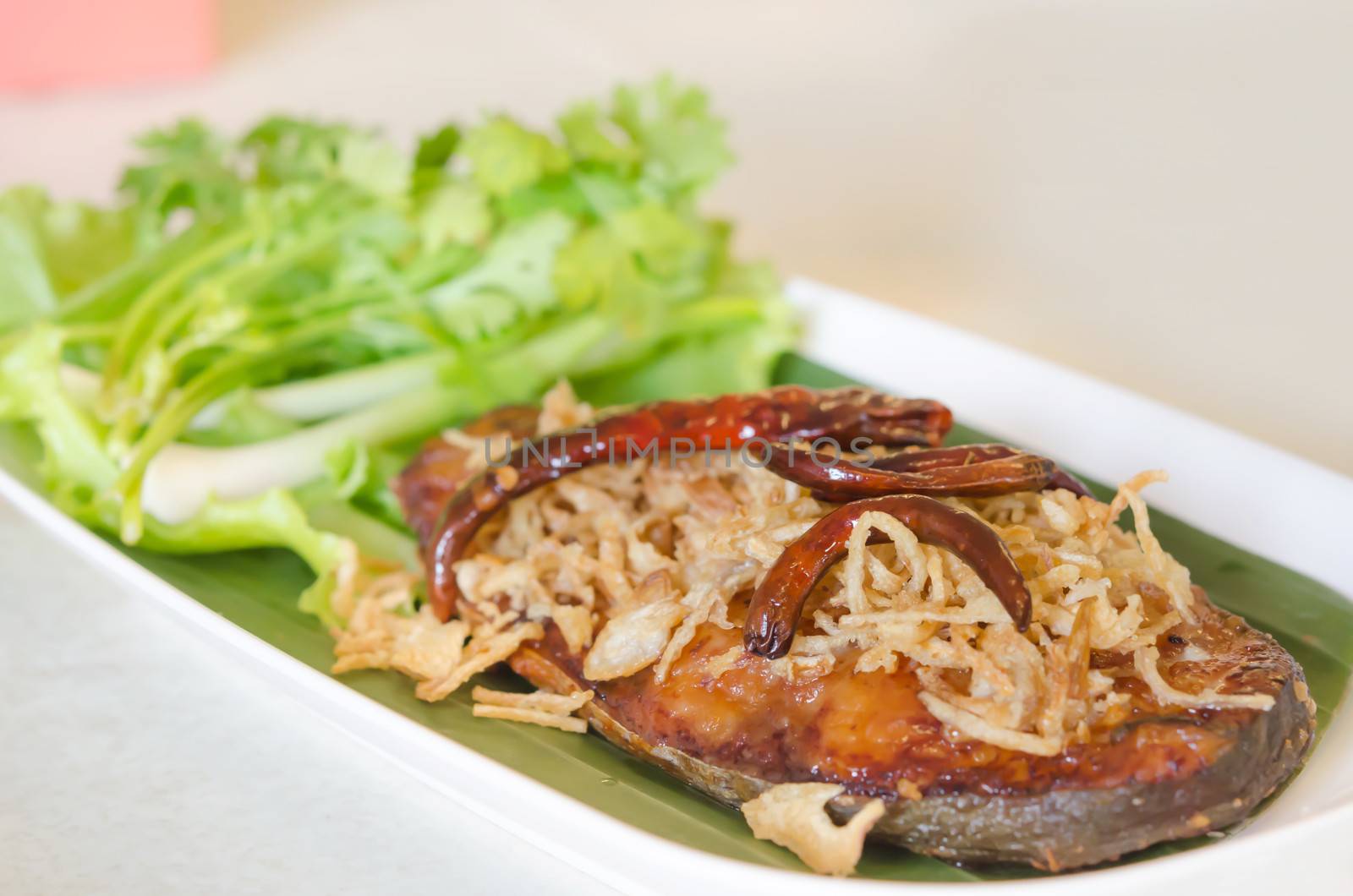 Fried pickled fish , onion  and chili served  with fresh vegetable on dish
