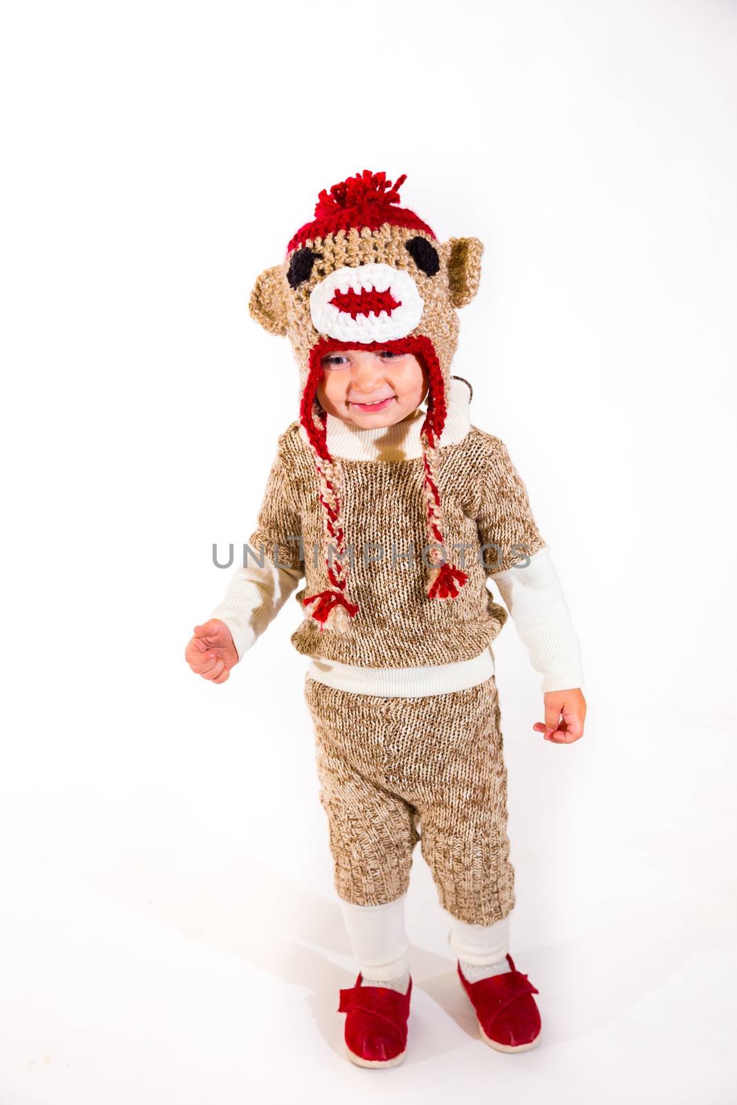 A two year old dressed up in a sock monkey halloween costume and ready to go out and trick-or-treat in the neighborhood for the holiday.