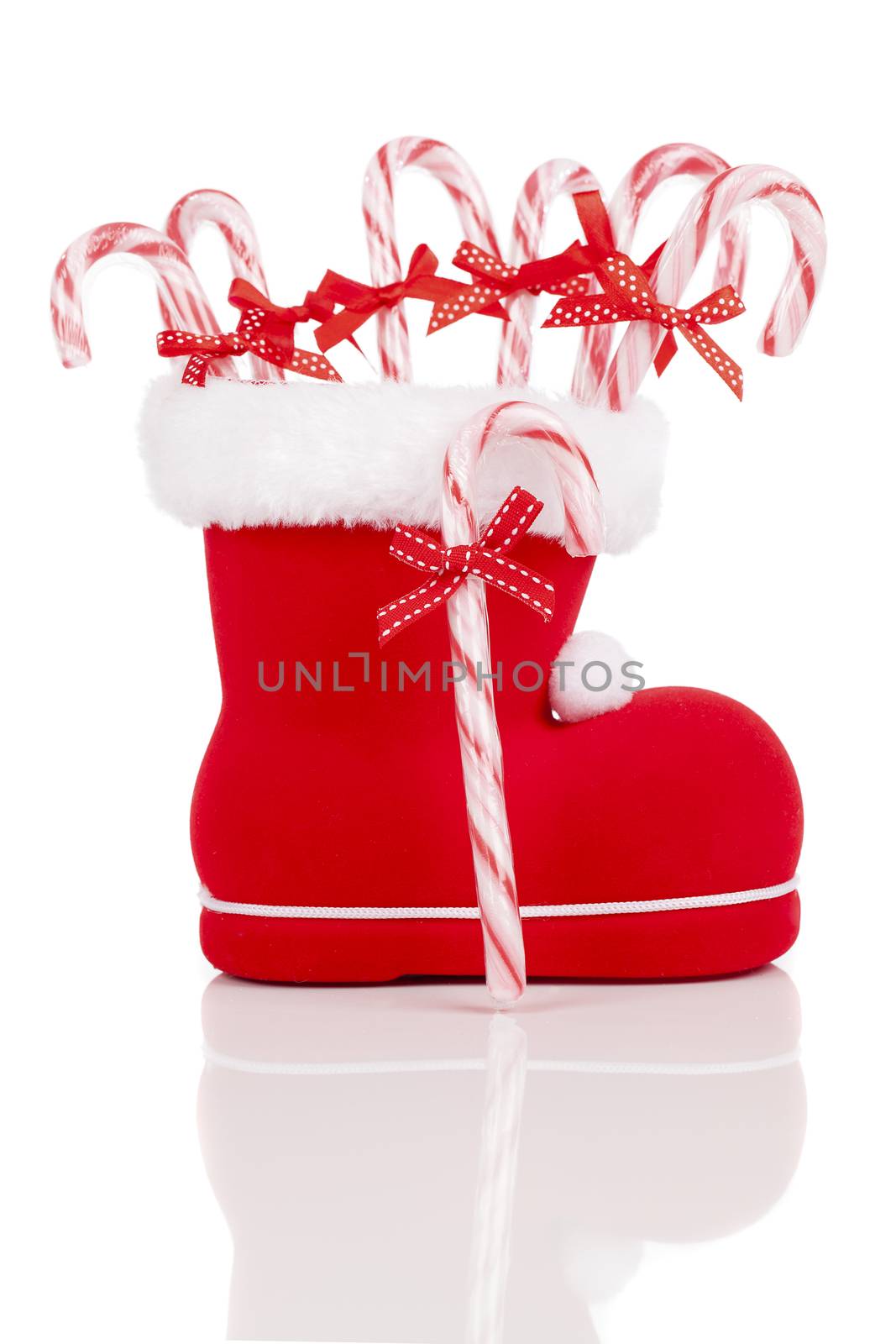 Santa's boot with candy canes on white background