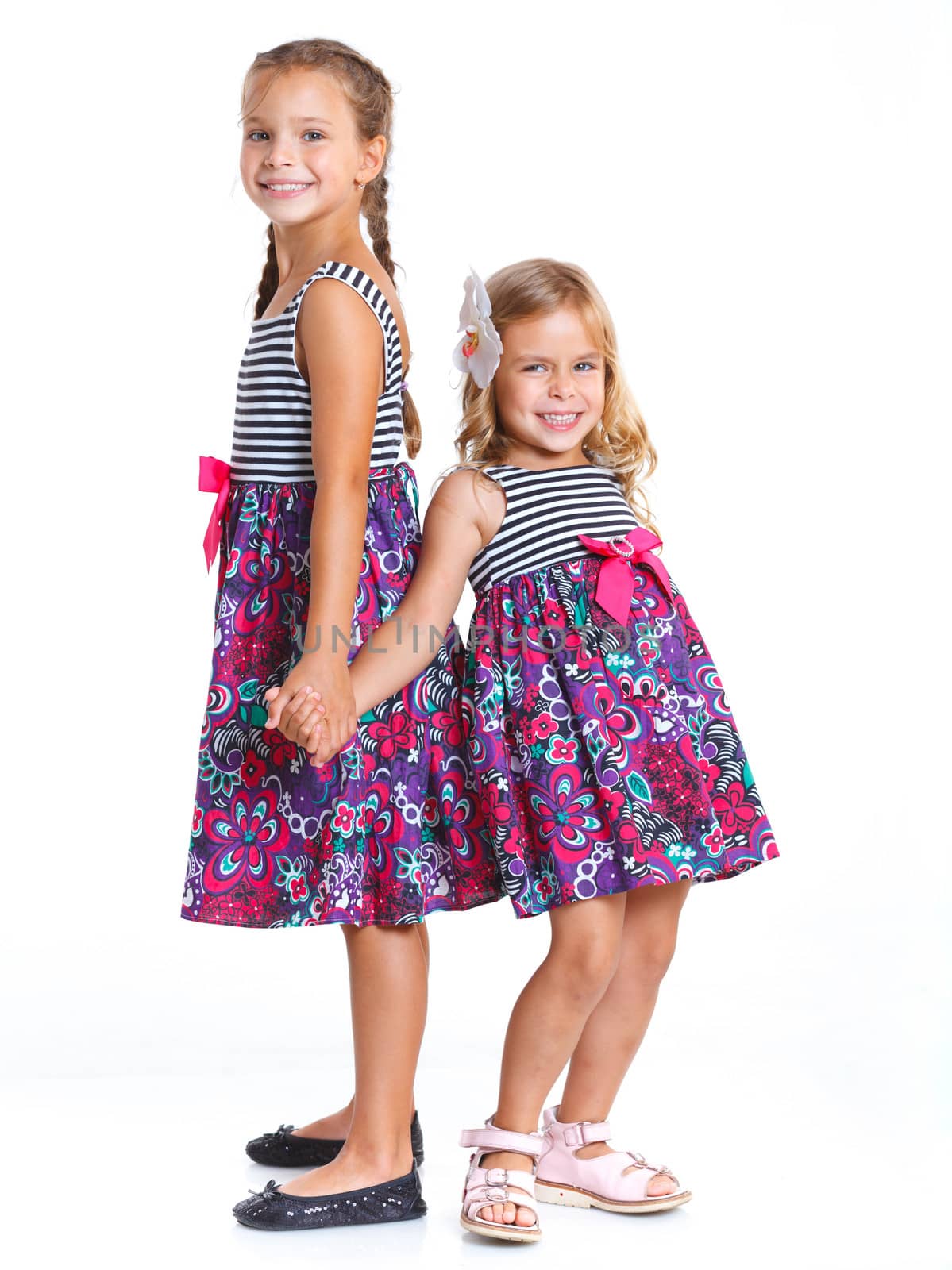 Two beautiful little girls happy smiling on studio. Isolated white background