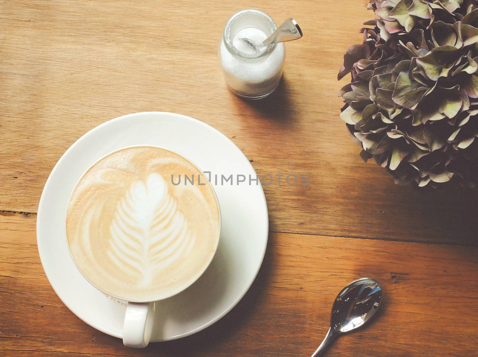 Cappuccino or latte coffee on table with retro filter effect by nuchylee