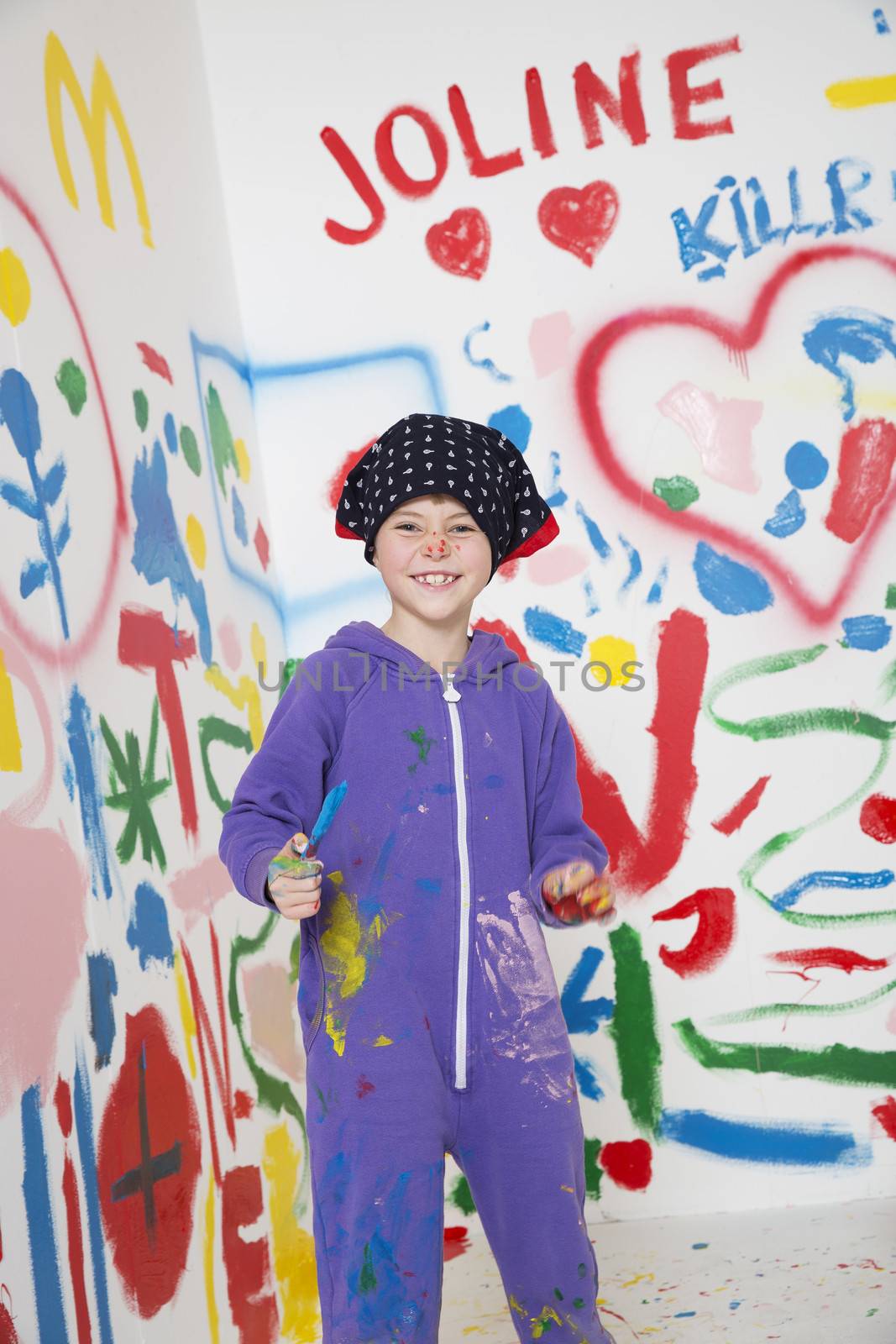 Smiling young artist painting in a white room