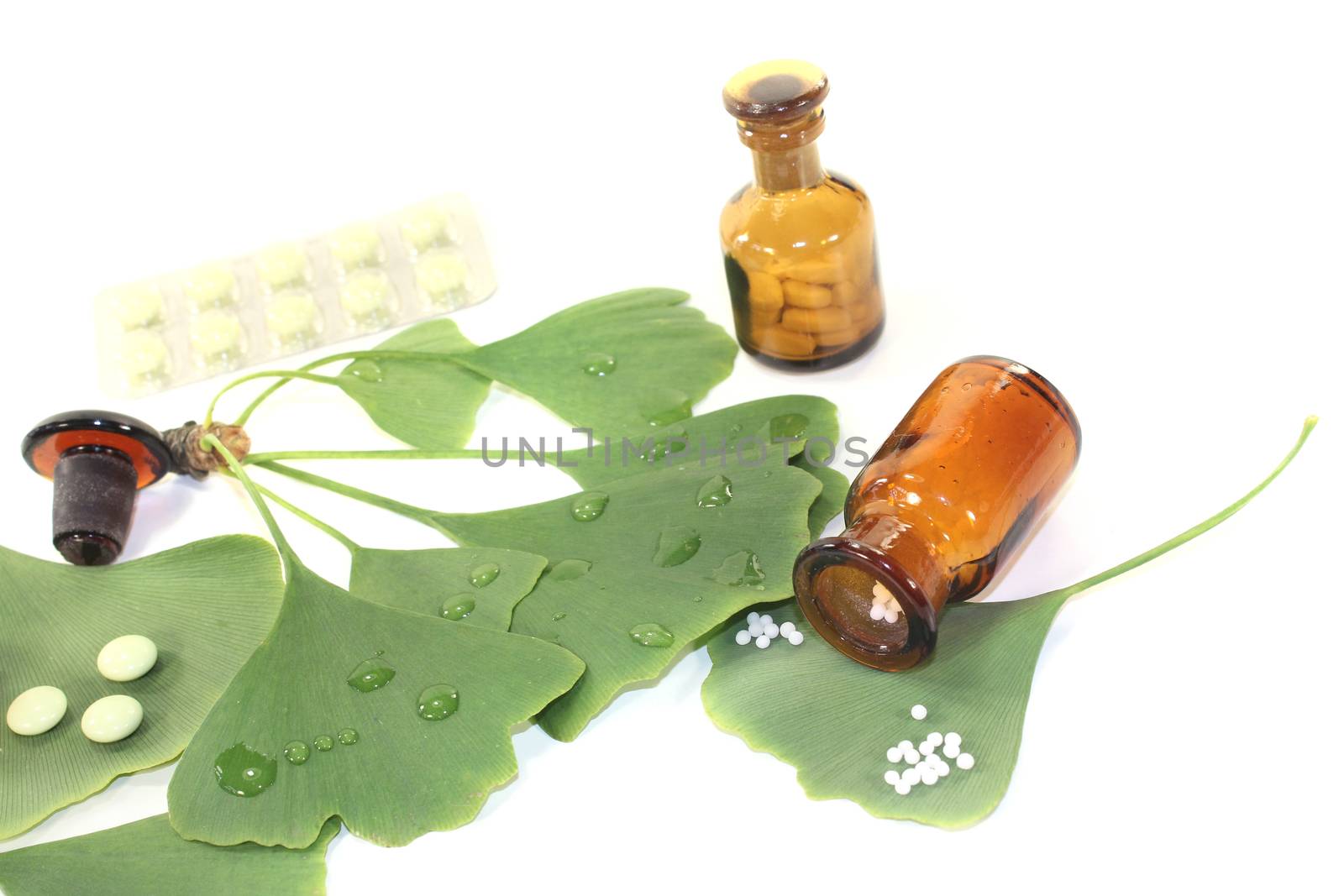 Ginkgo leaf with pills and pharmacist bottle on bright background