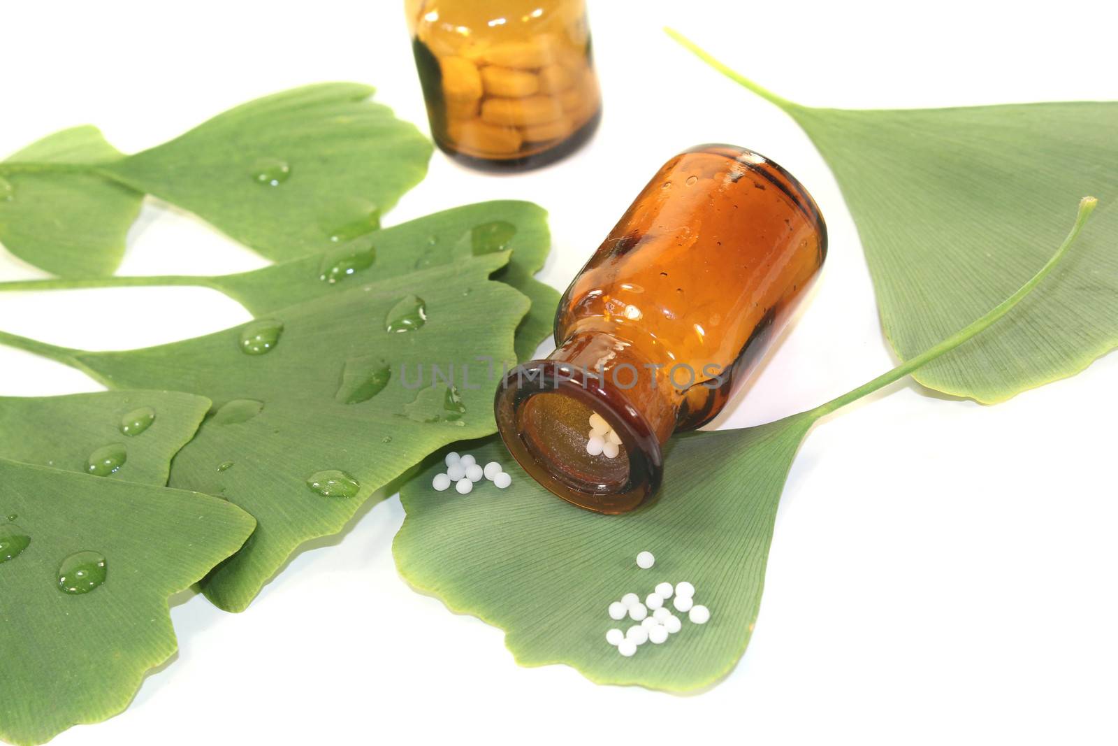 Ginkgo leaves with globules and pharmacist bottles by discovery