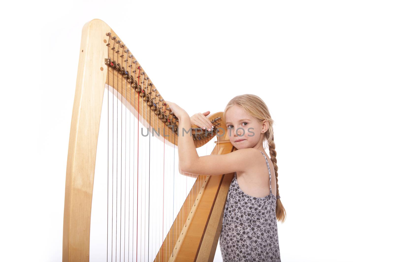 young girl in dress and her harp in studio against white background