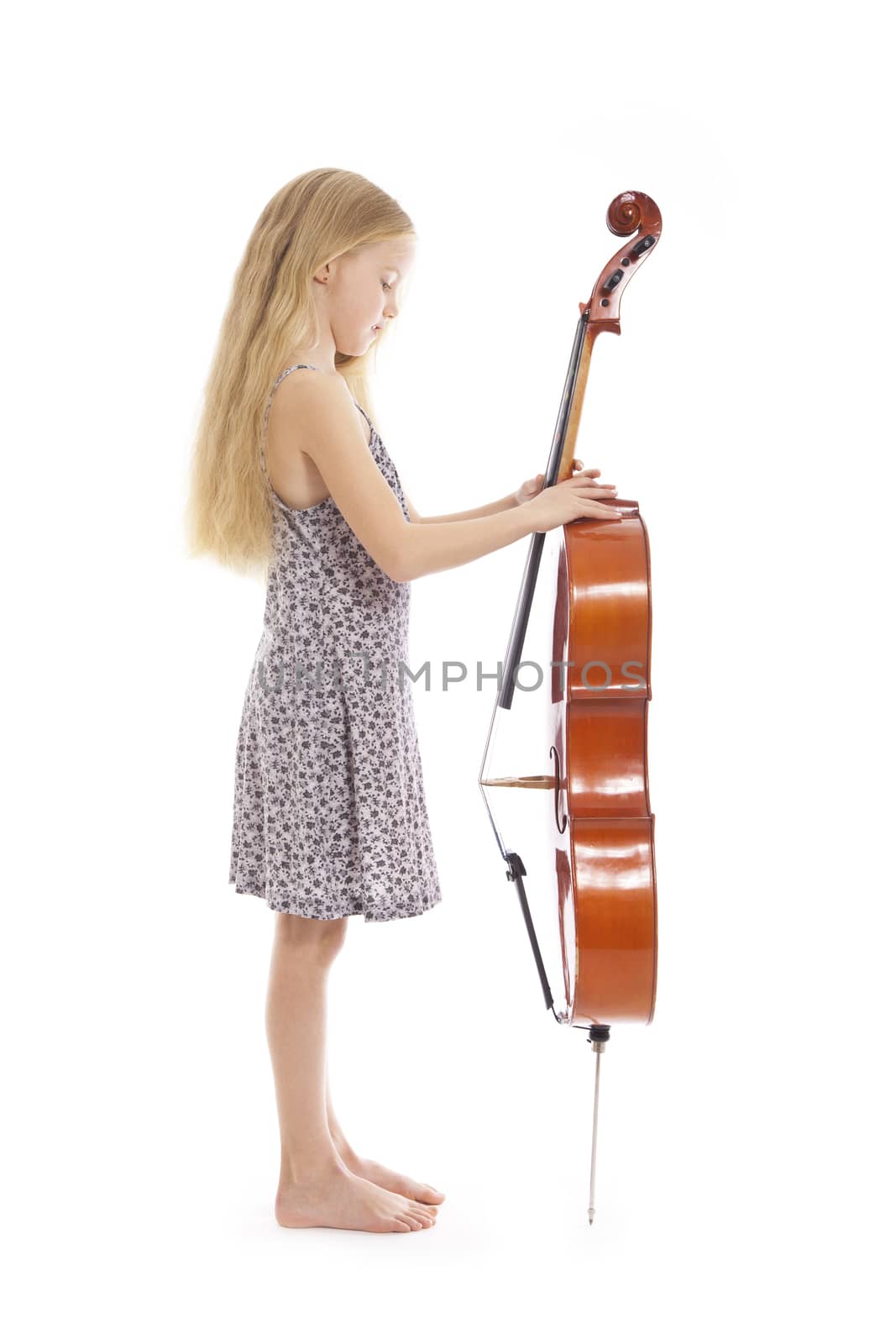 young girl in dress and her cello standing in studio against white background