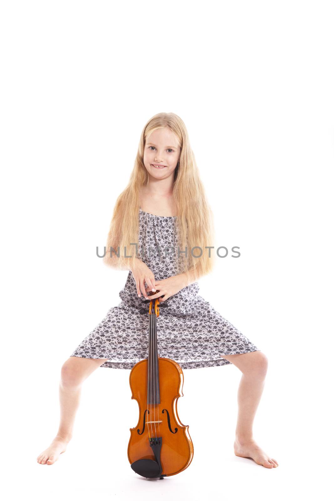 young girl in dress standing with her violin against white background